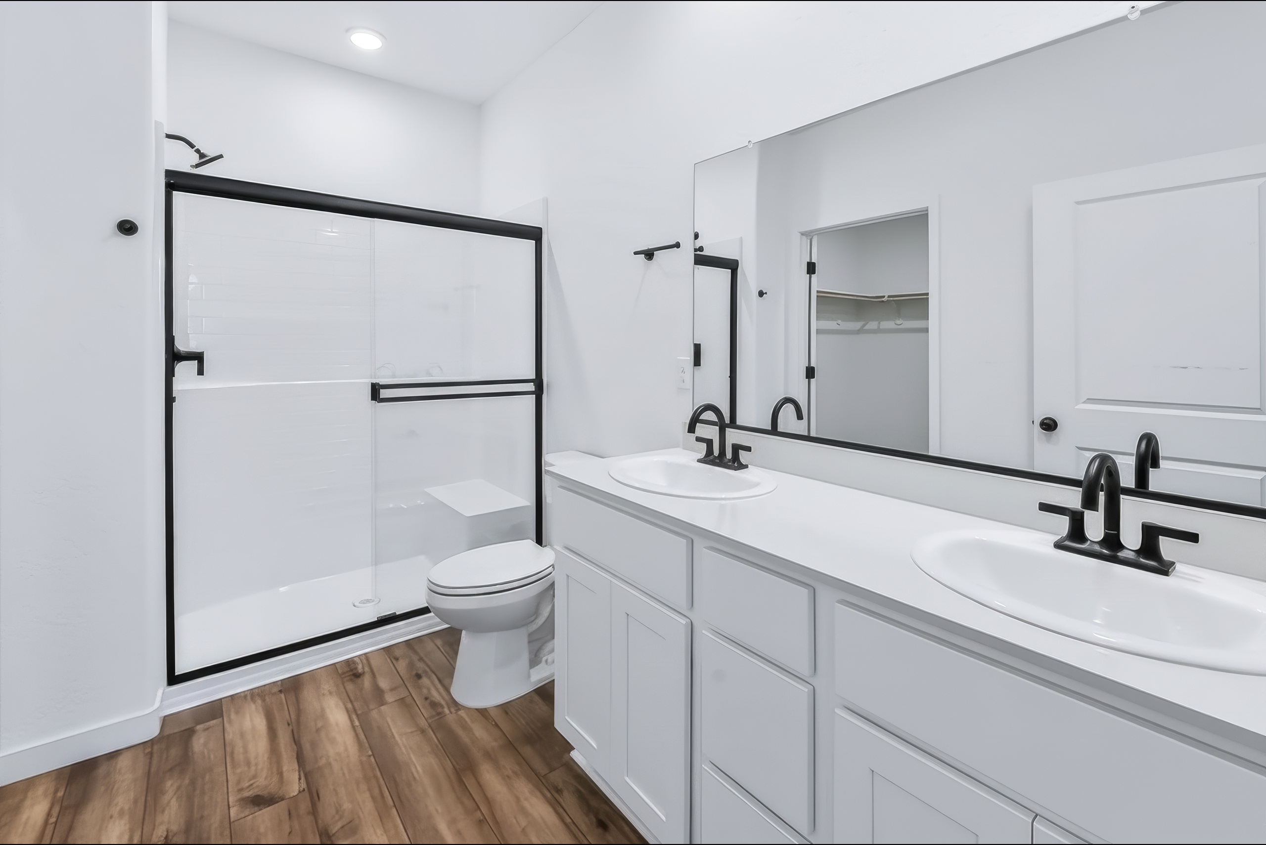 A bathroom with a sink toilet and mirror.