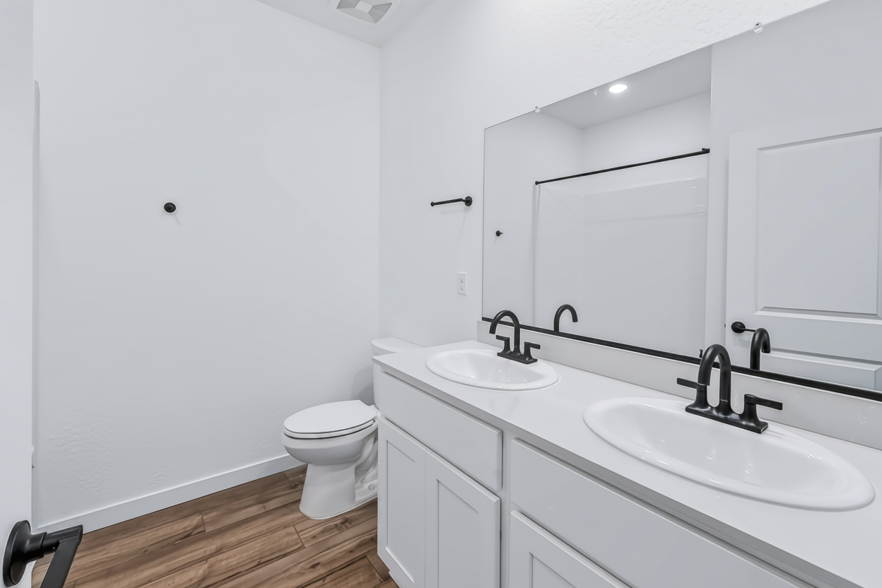 A bathroom with a toilet sink and a mirror.