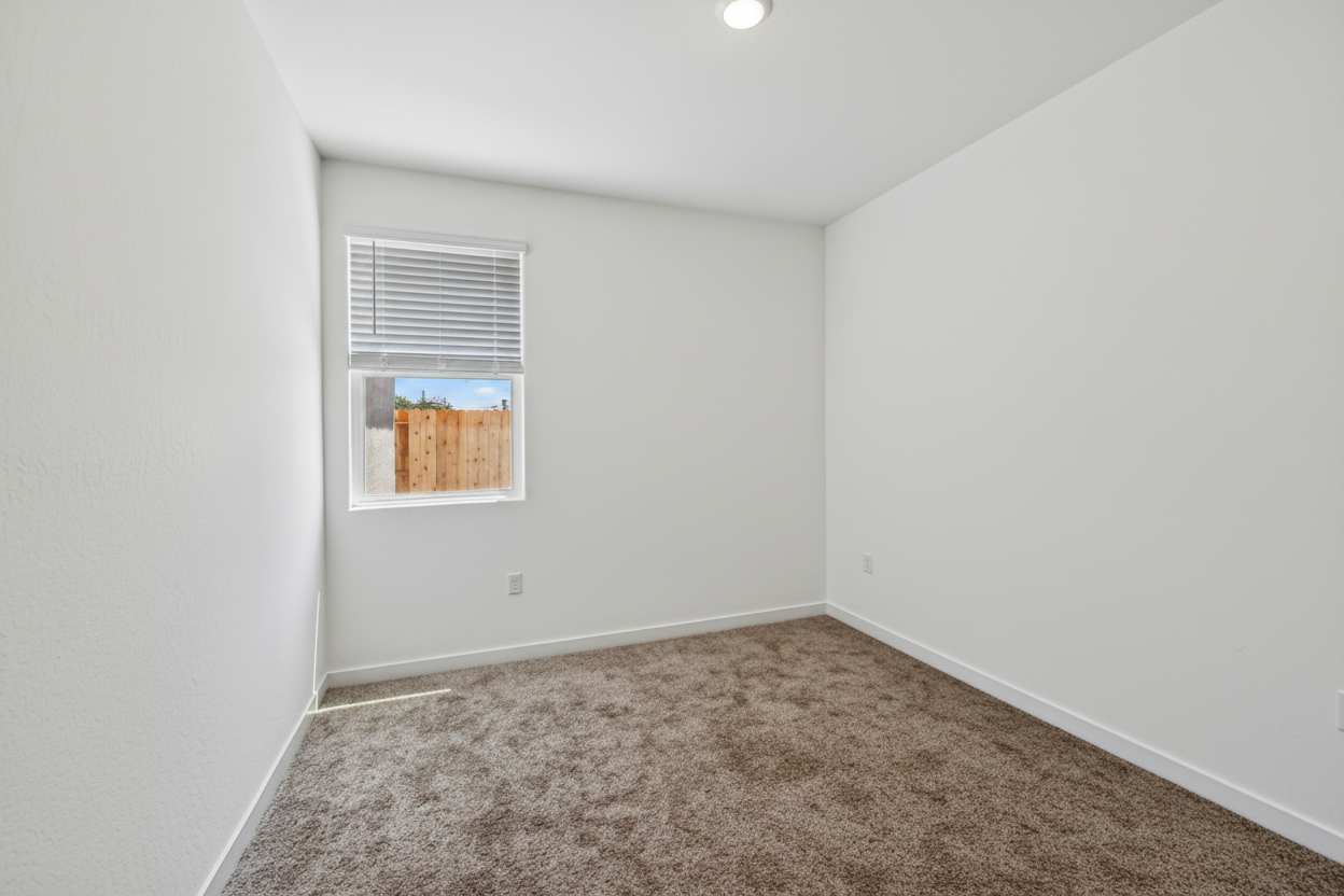 A room with a window and carpet.