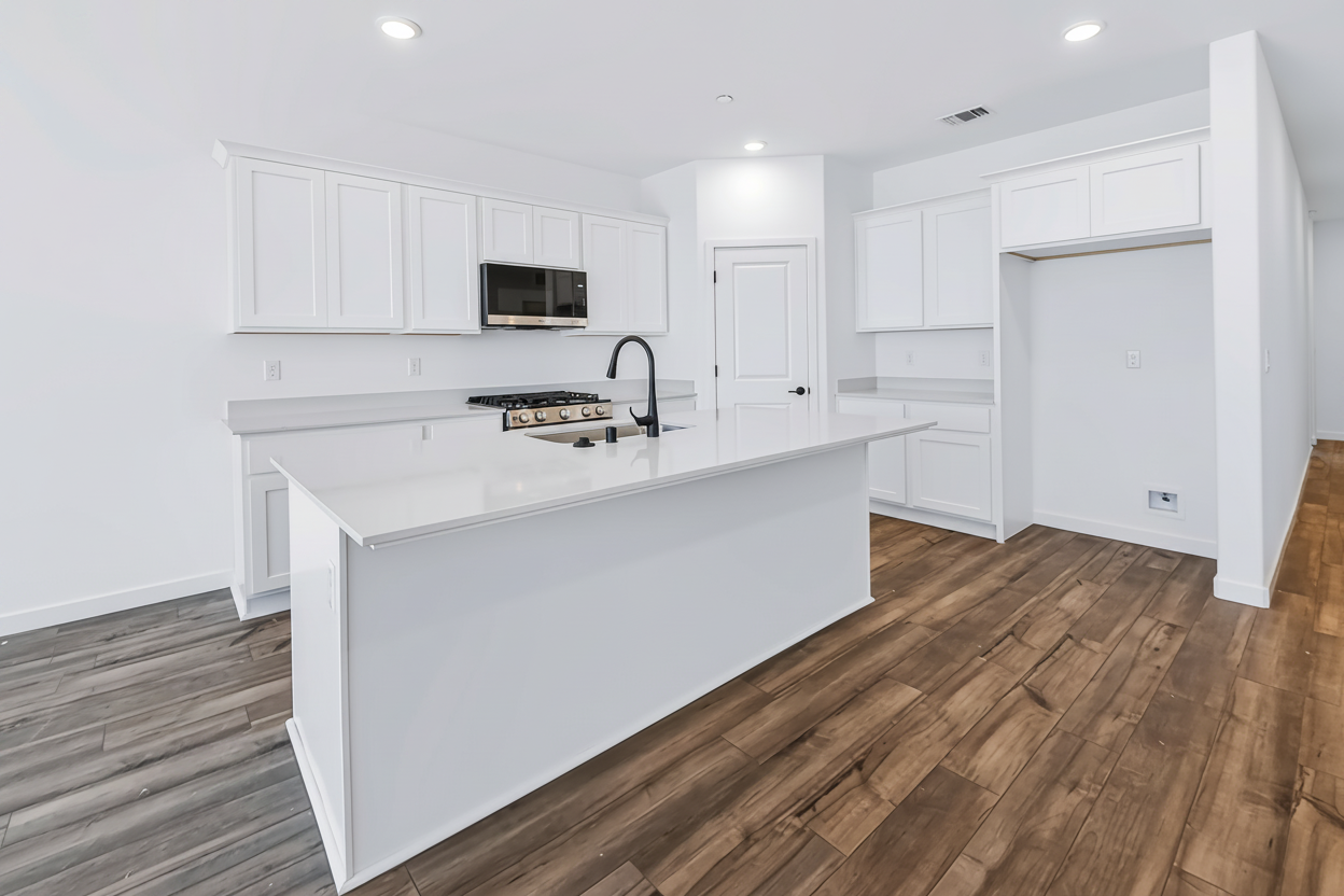 A kitchen with white cabinets.