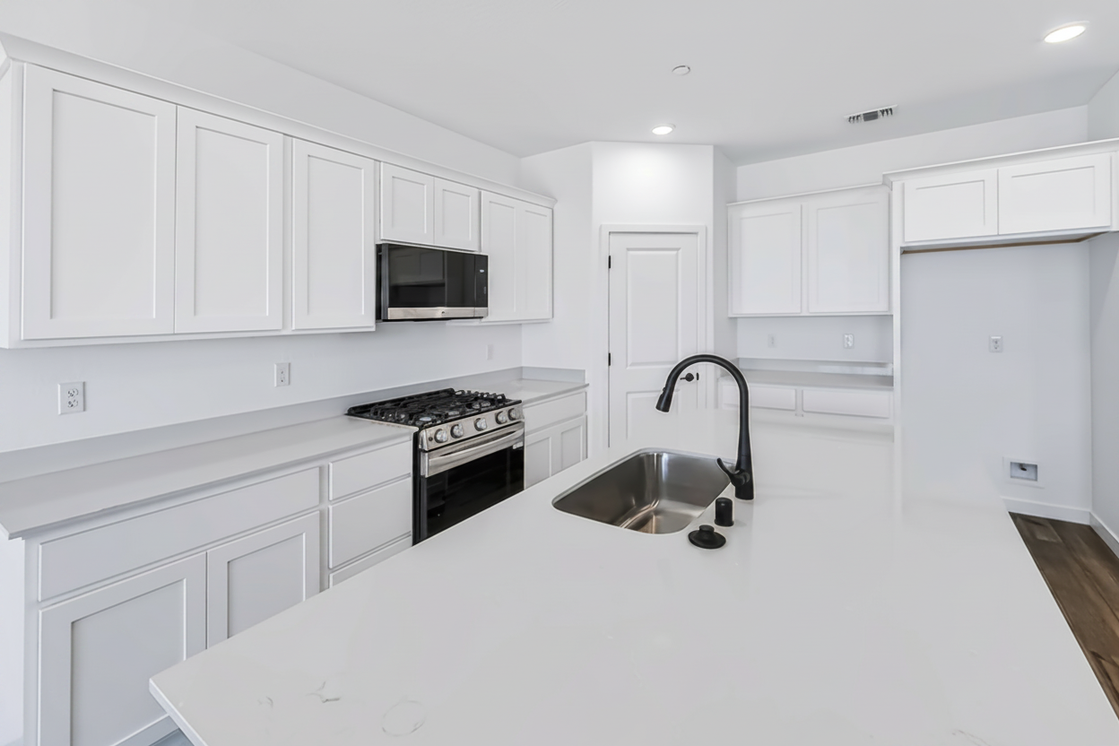 A kitchen with white cabinets.
