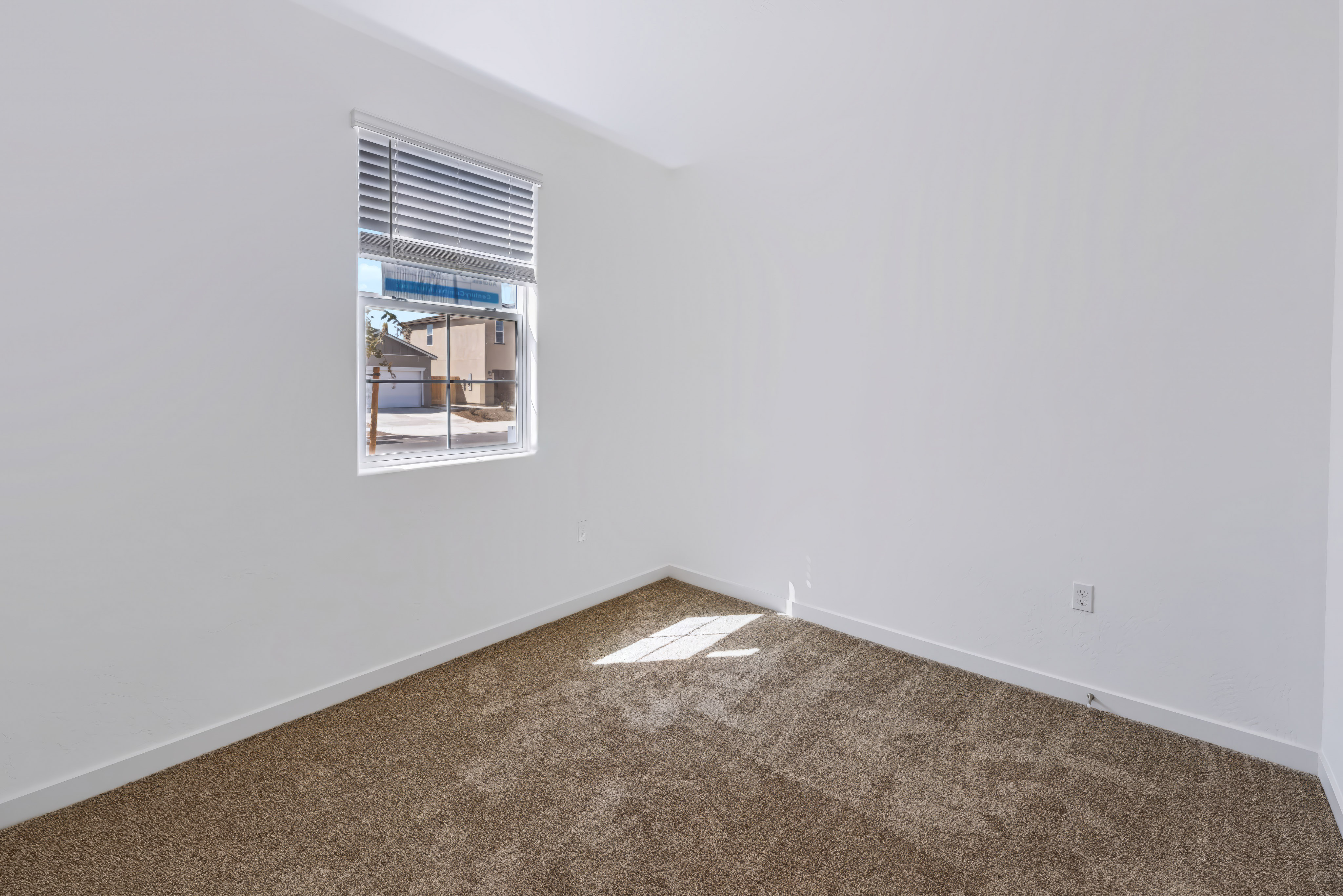 A room with a window and carpet.
