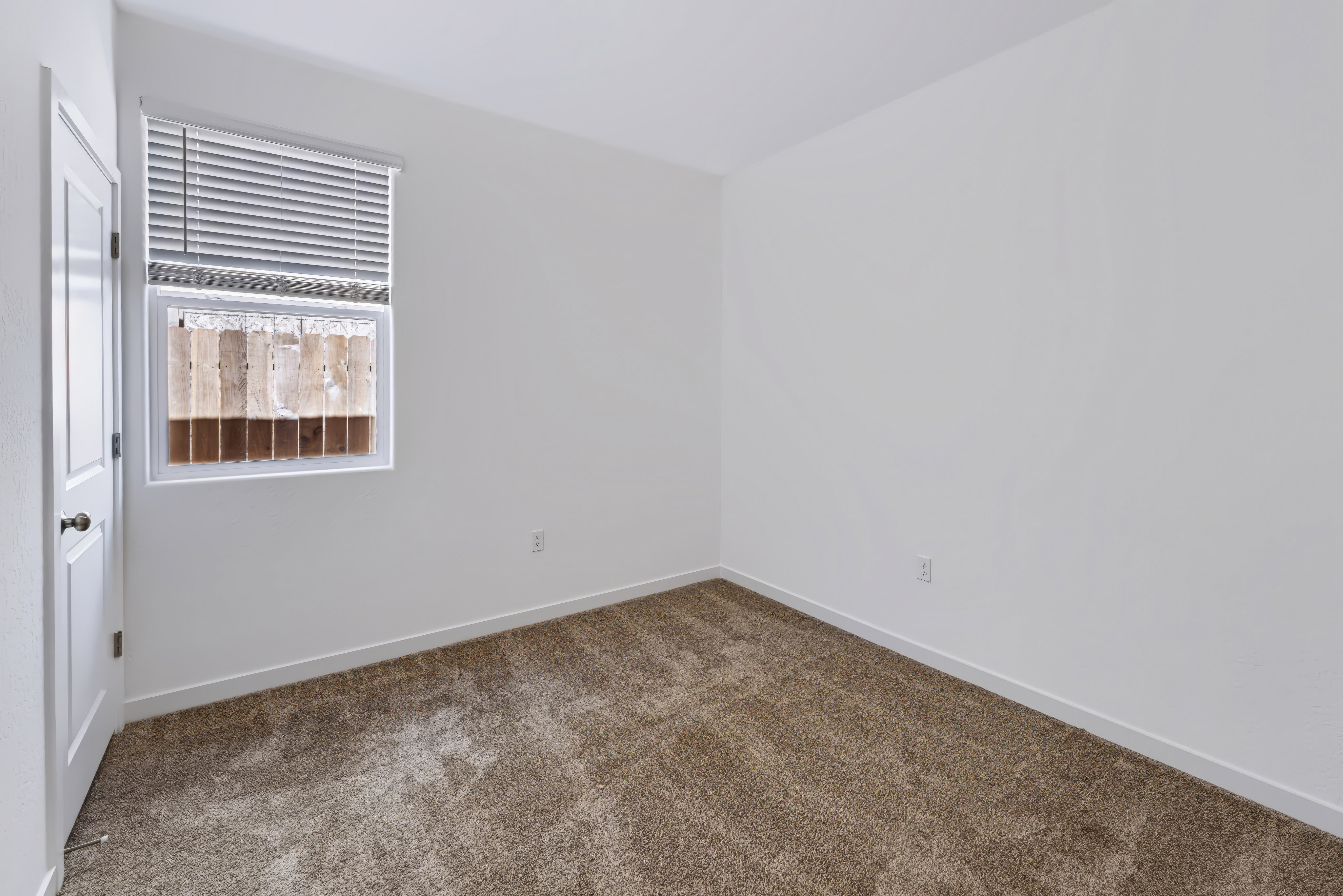 A room with a carpet and a window.