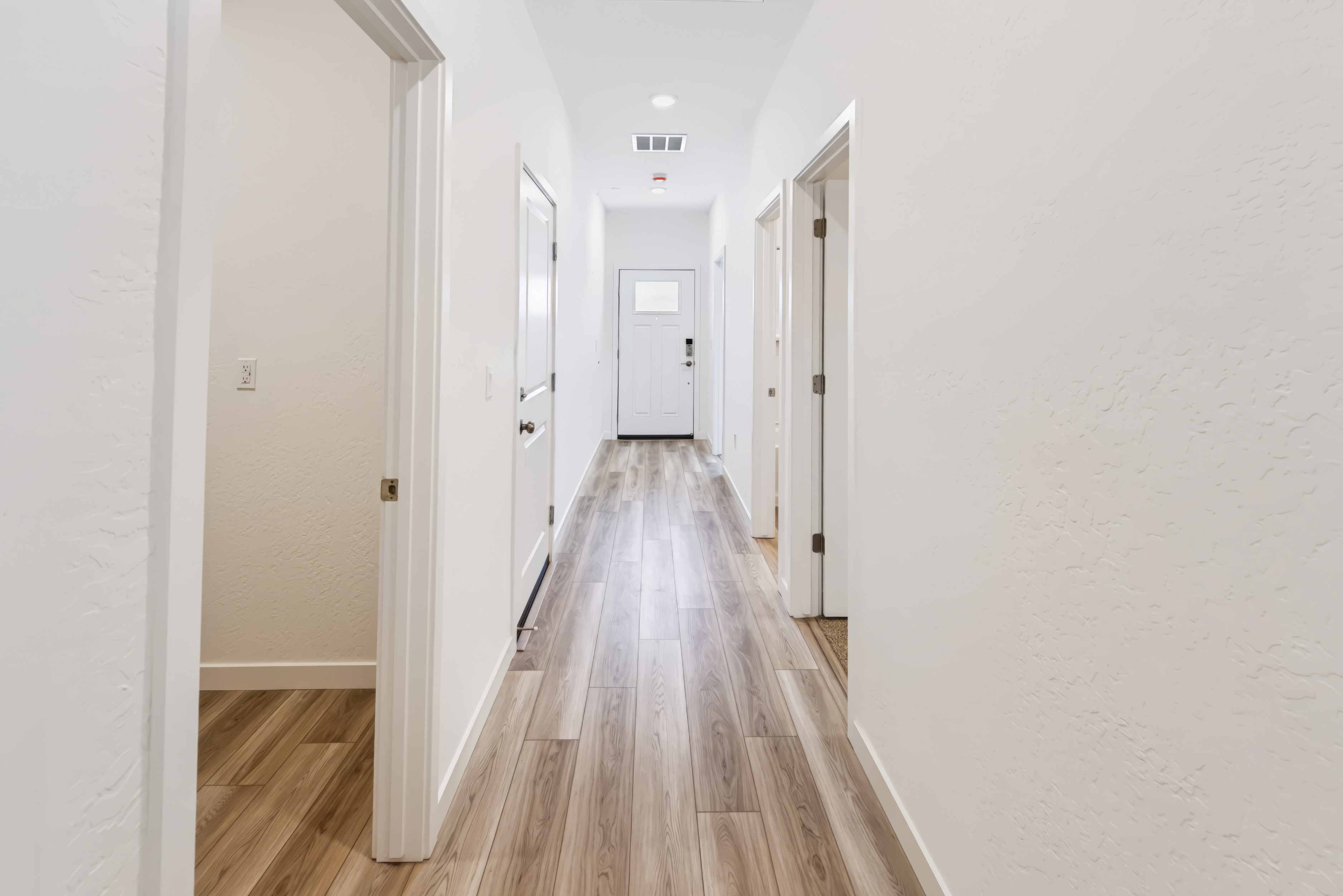 A long hallway with white doors.