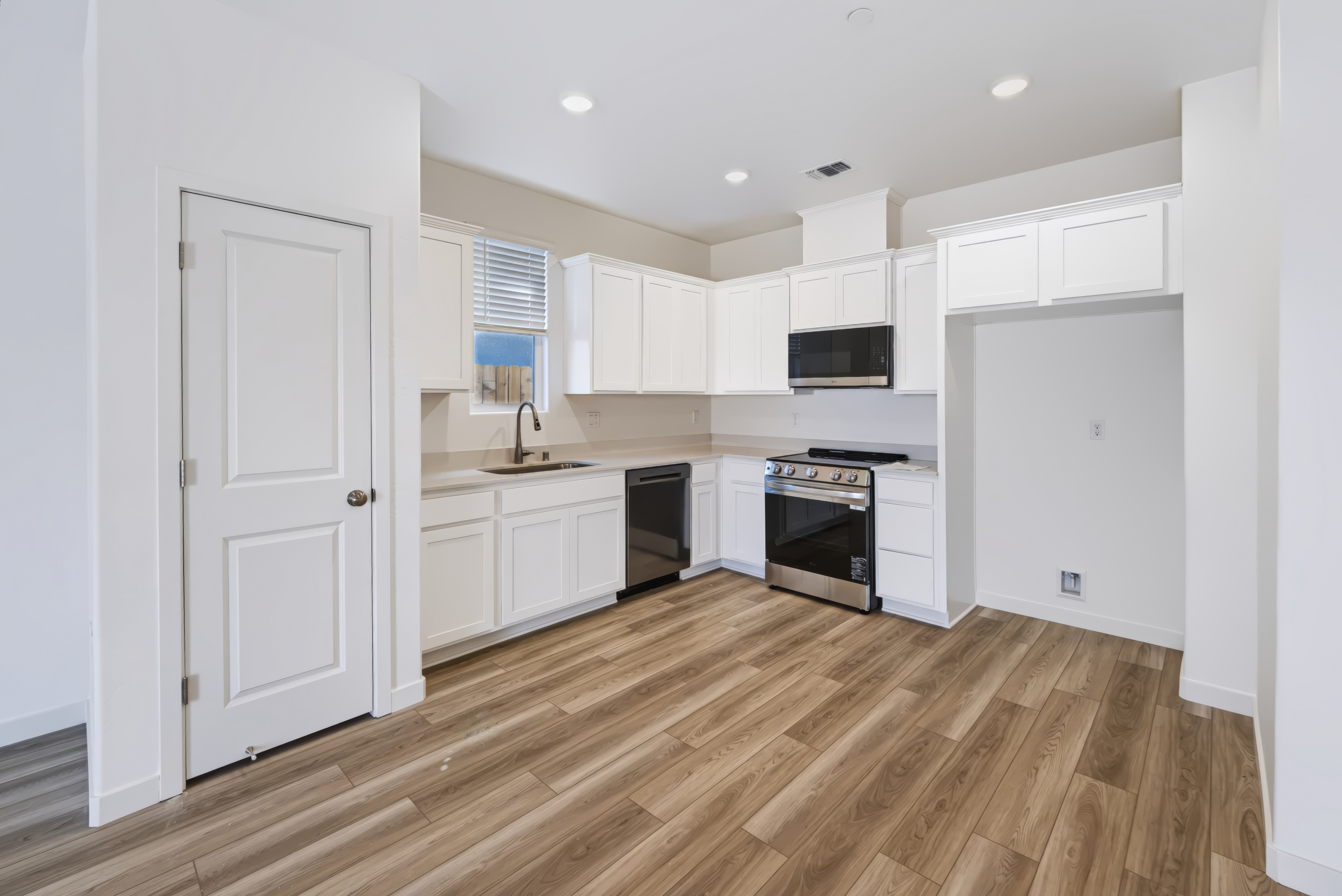 A kitchen with white cabinets.