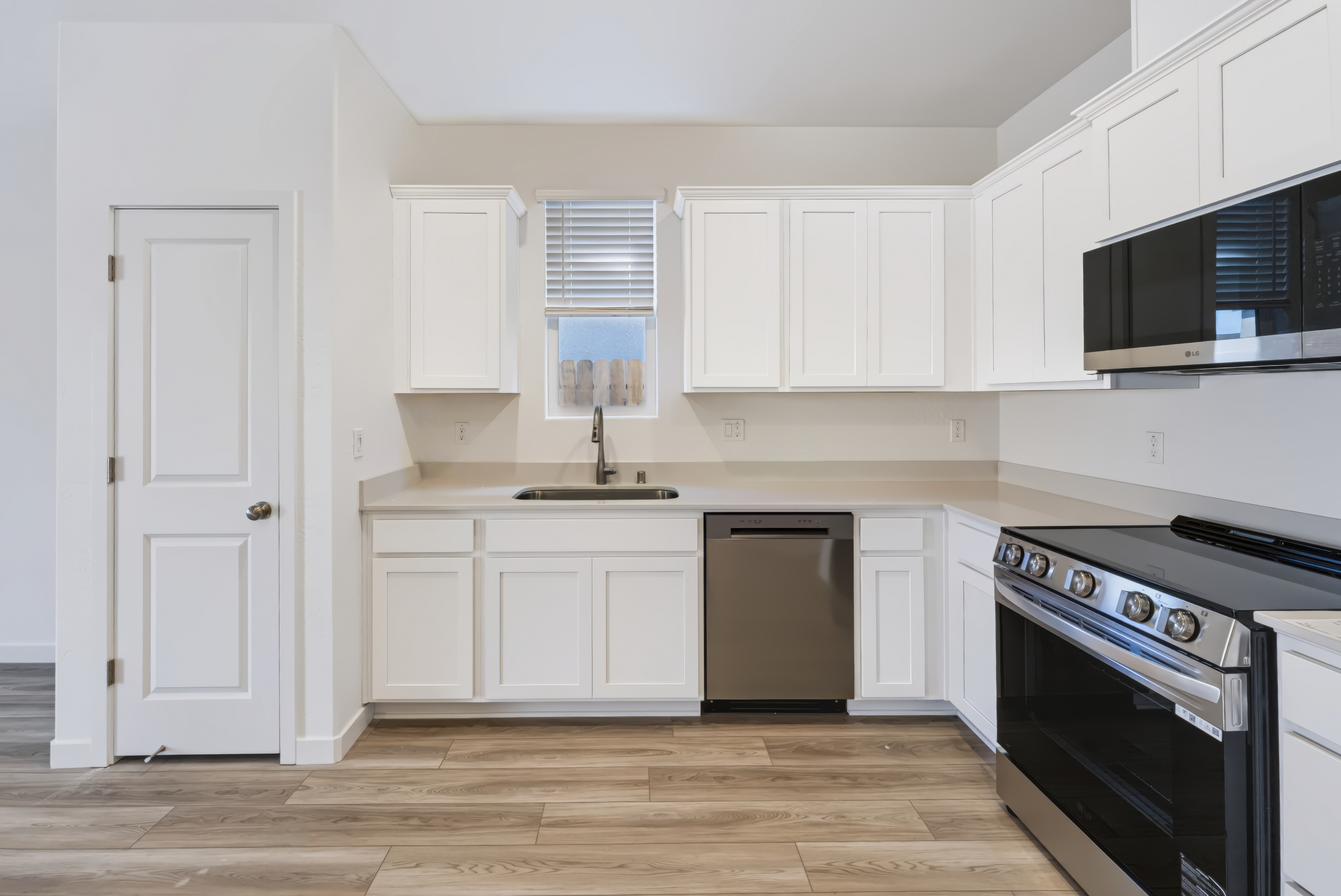 A kitchen with white cabinets.