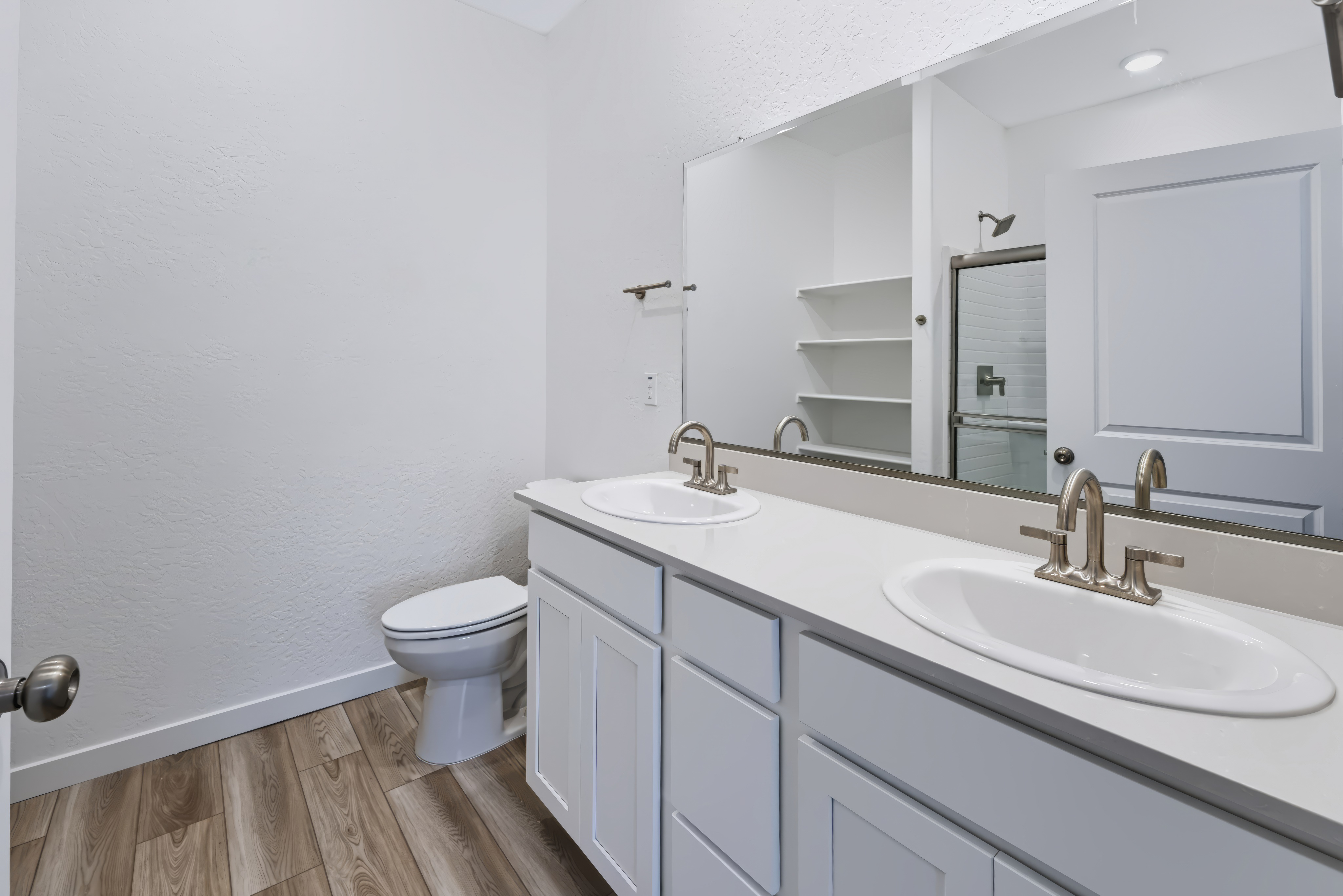 A bathroom with a sink toilet and mirror.
