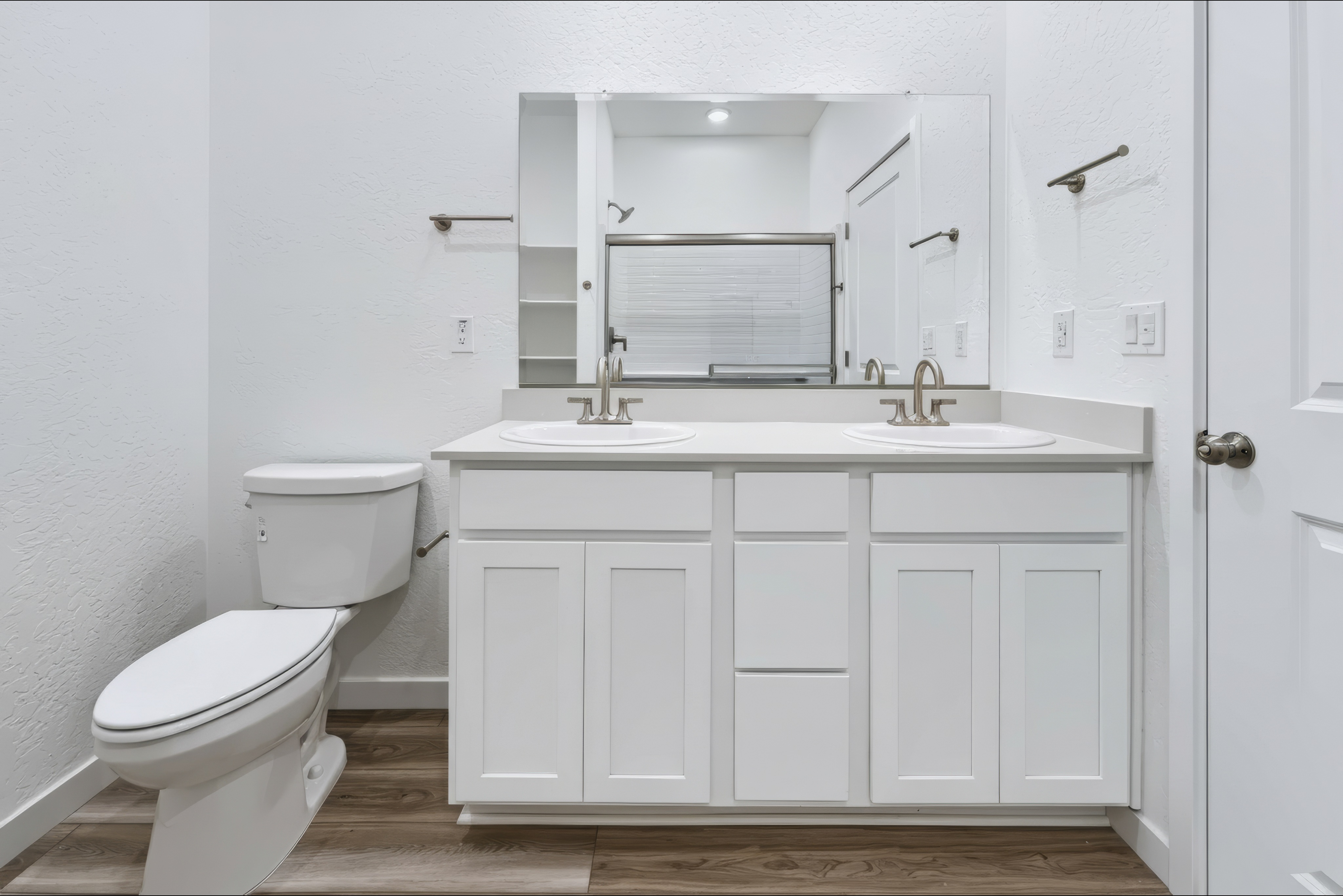 A bathroom with white cabinets.