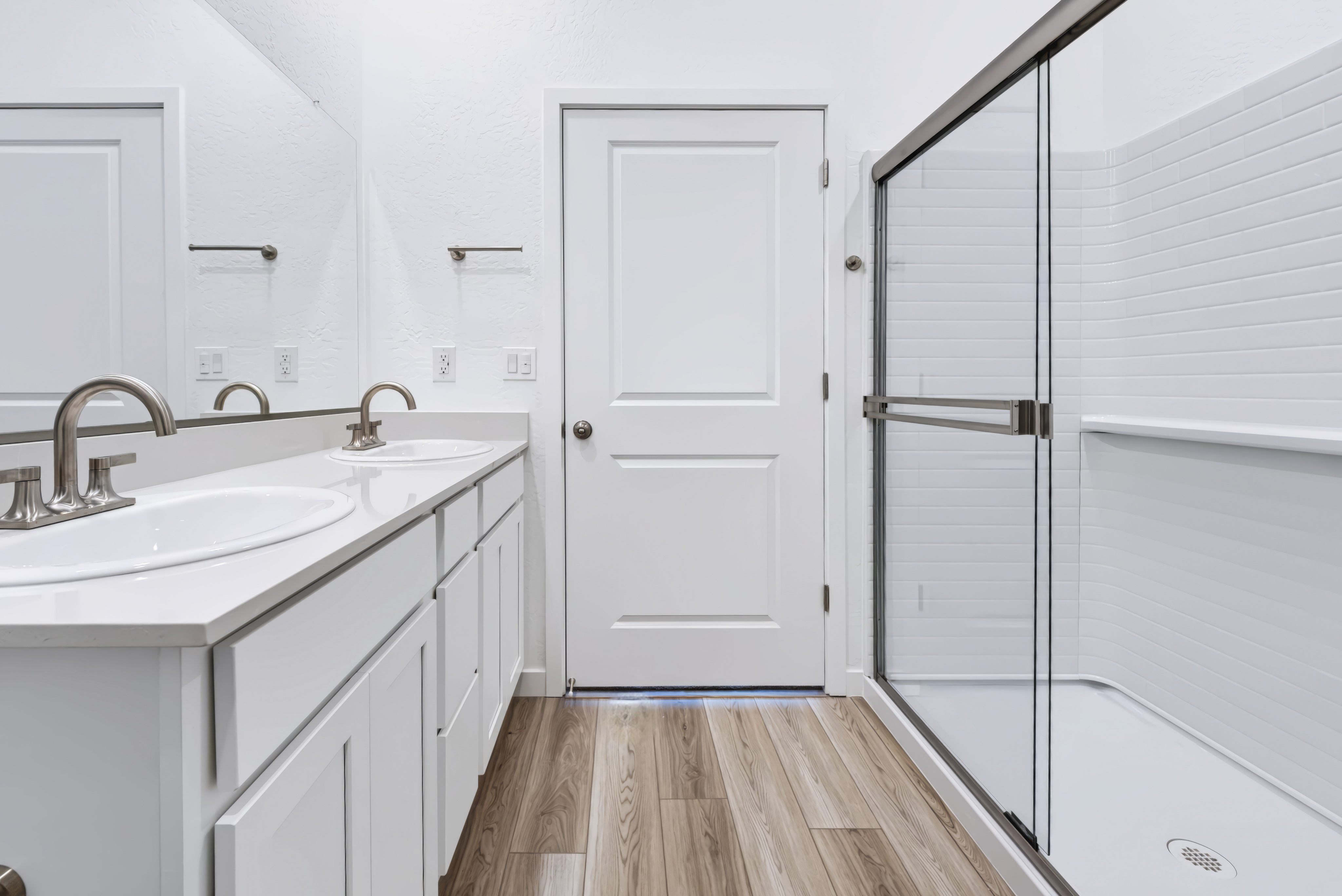 A bathroom with white cabinets.