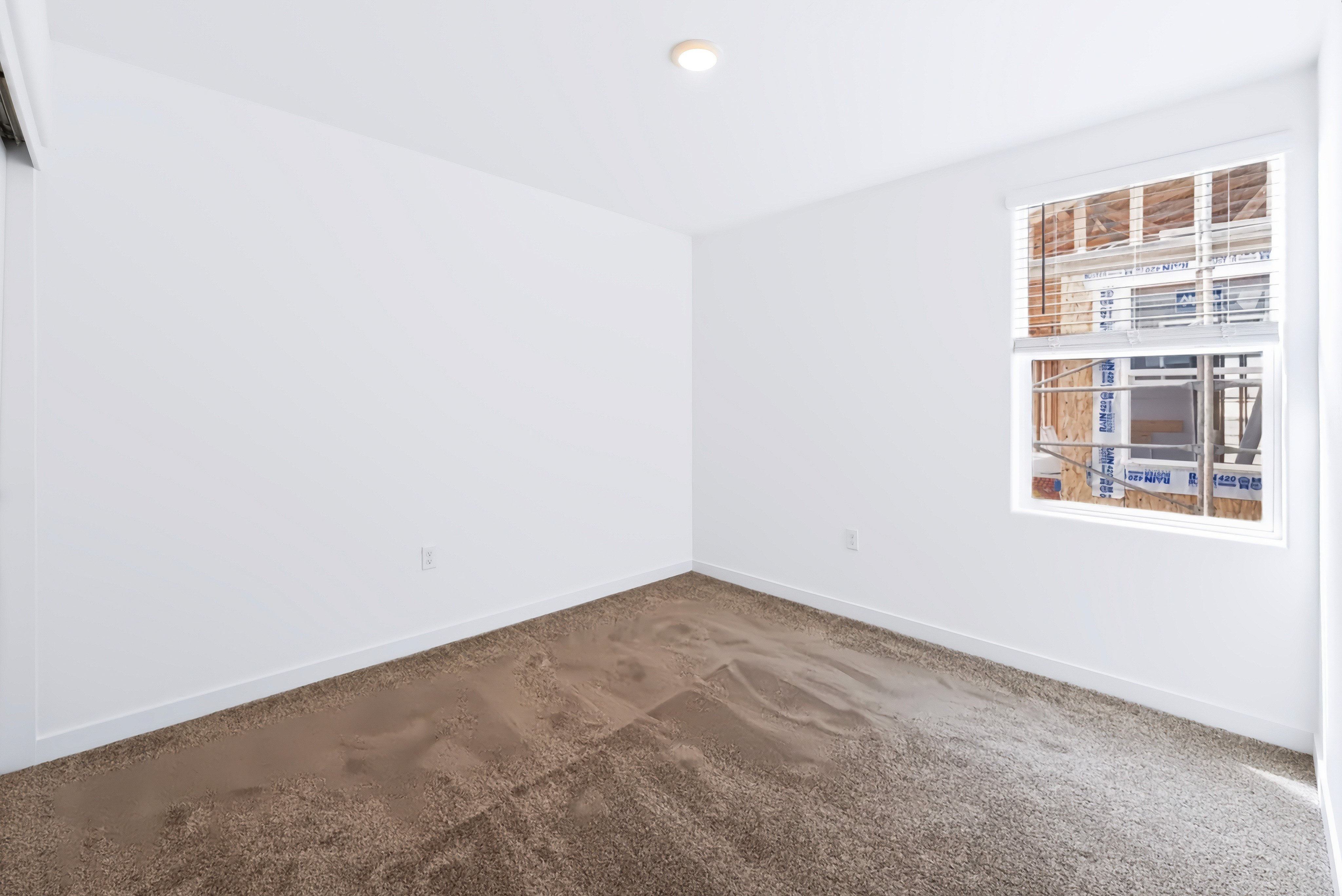 A room with a window and a carpet.
