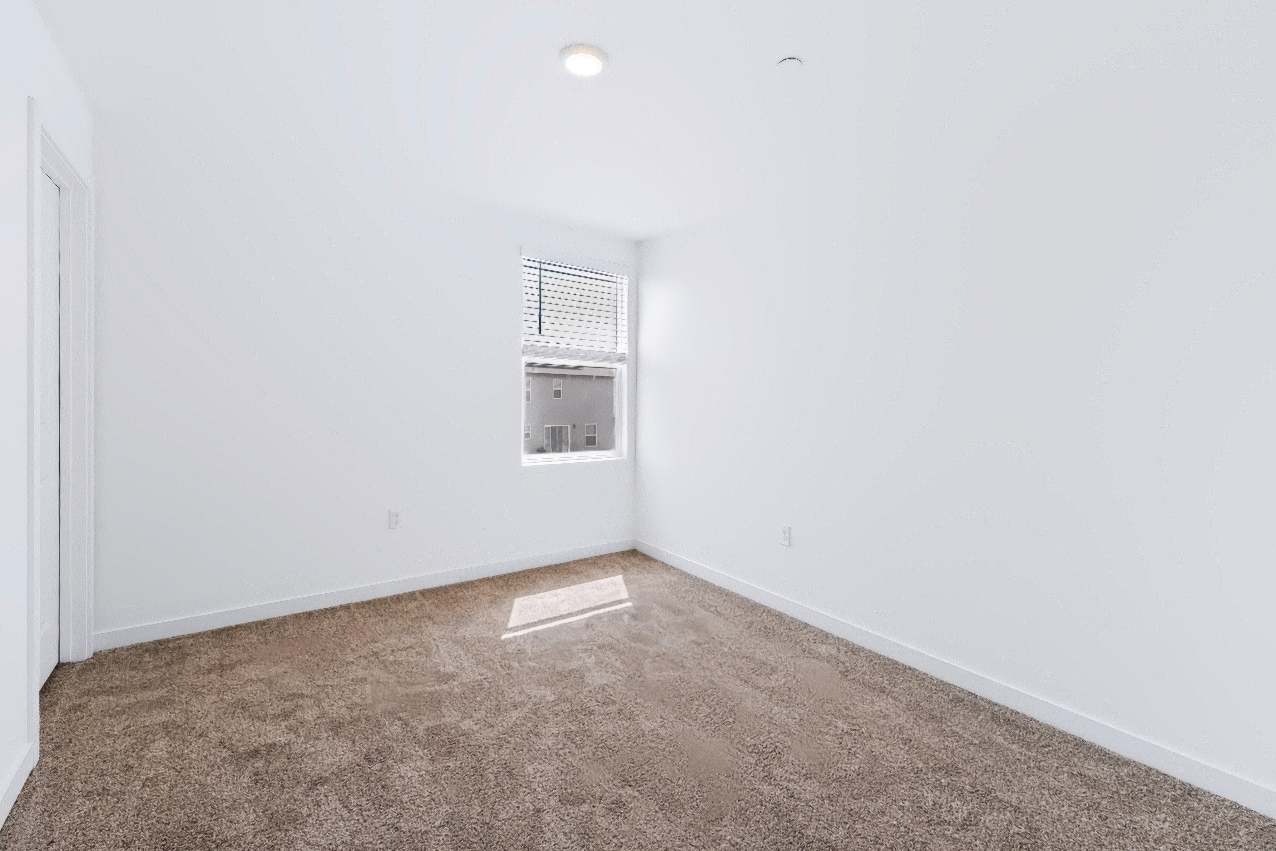 A room with a carpet and a vent.