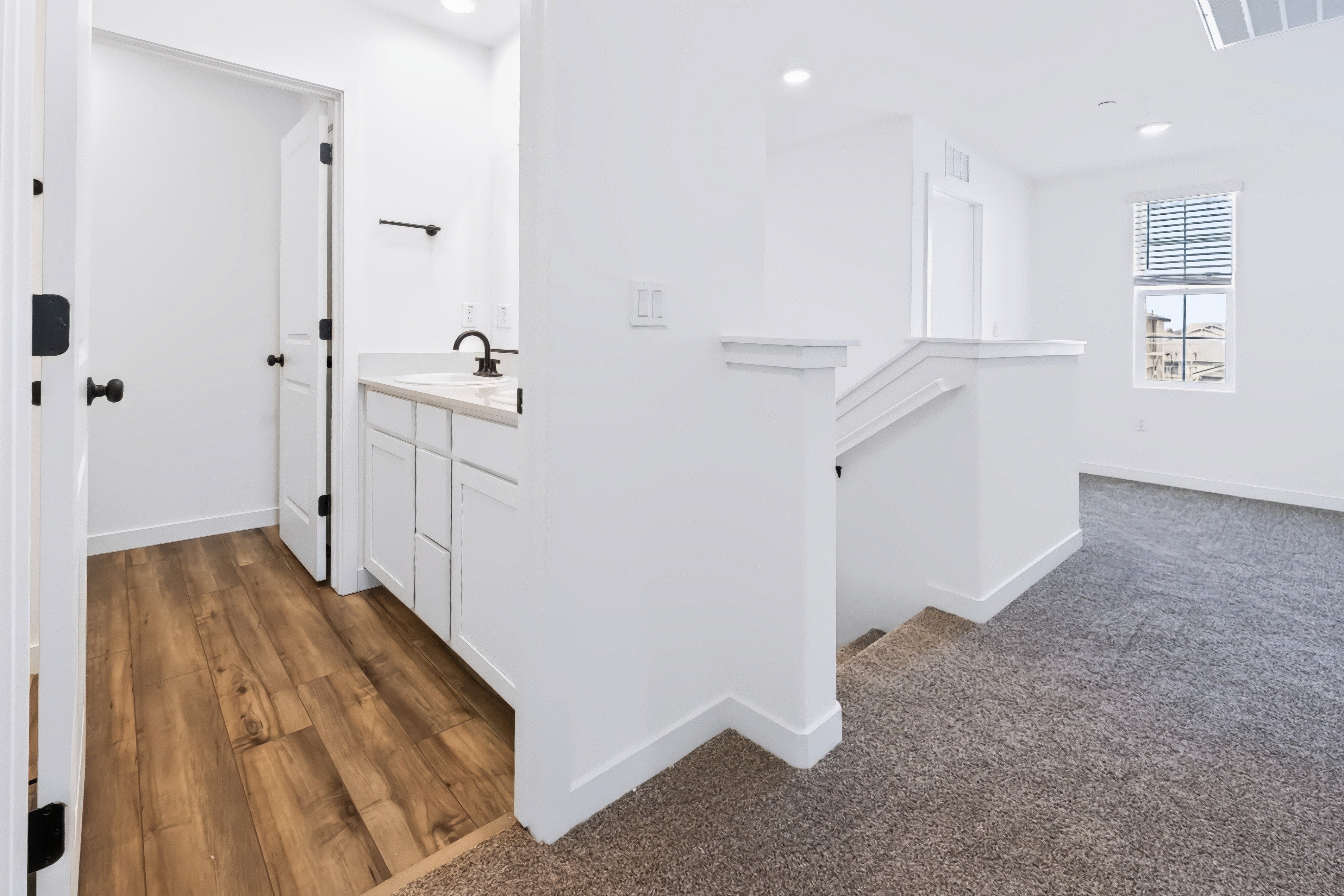 A bathroom with white cabinets.
