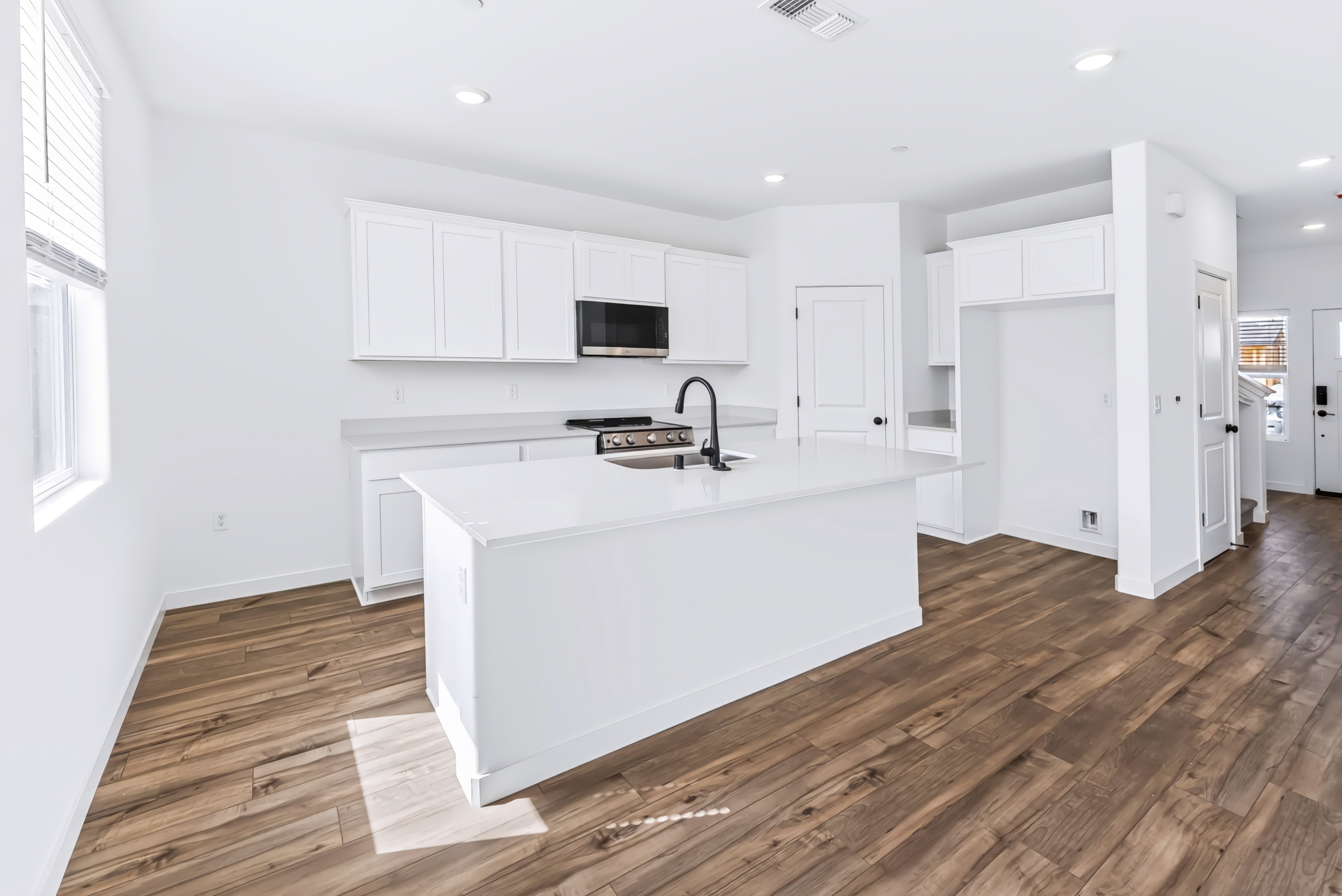 A kitchen with white cabinets.
