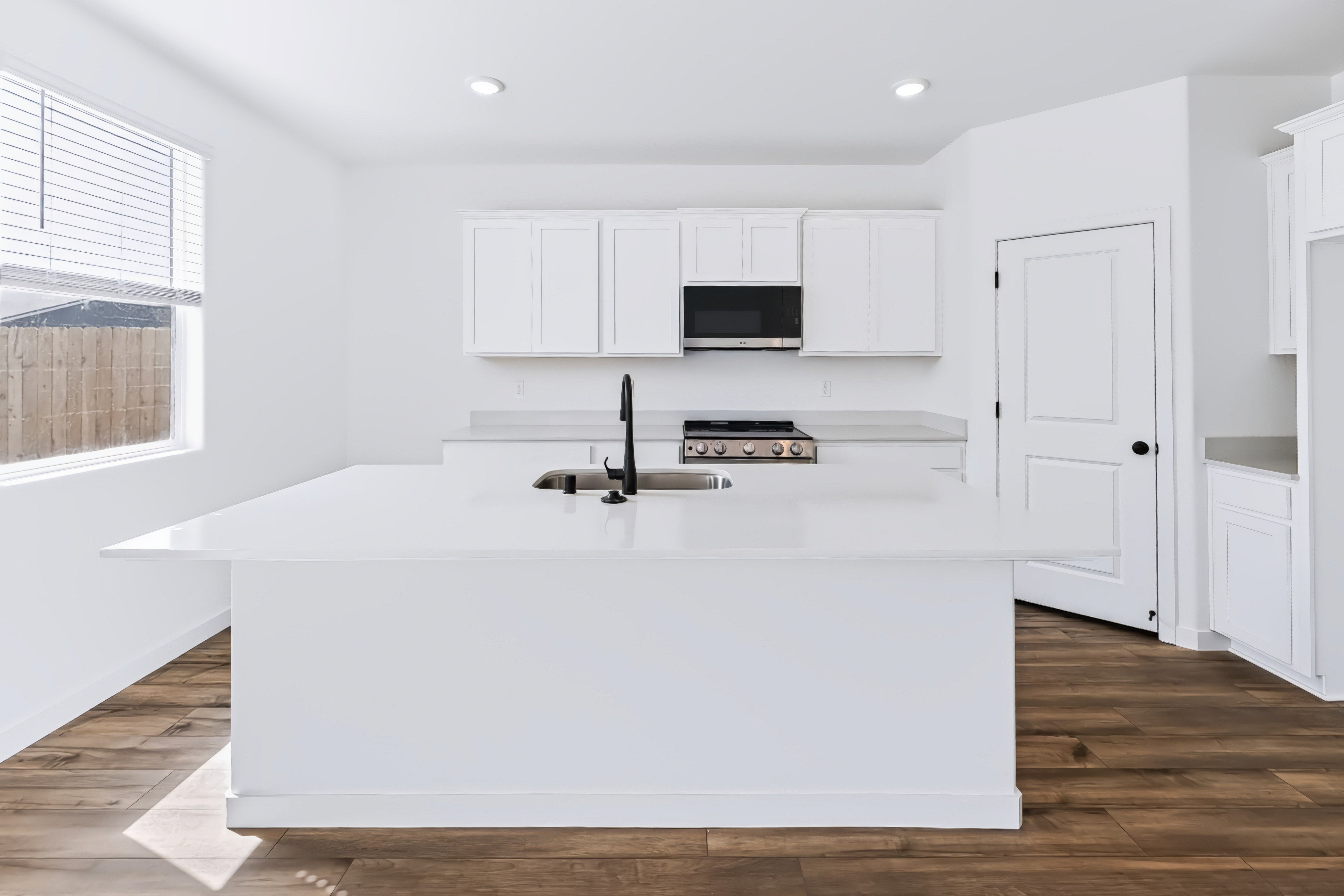 A kitchen with white cabinets.