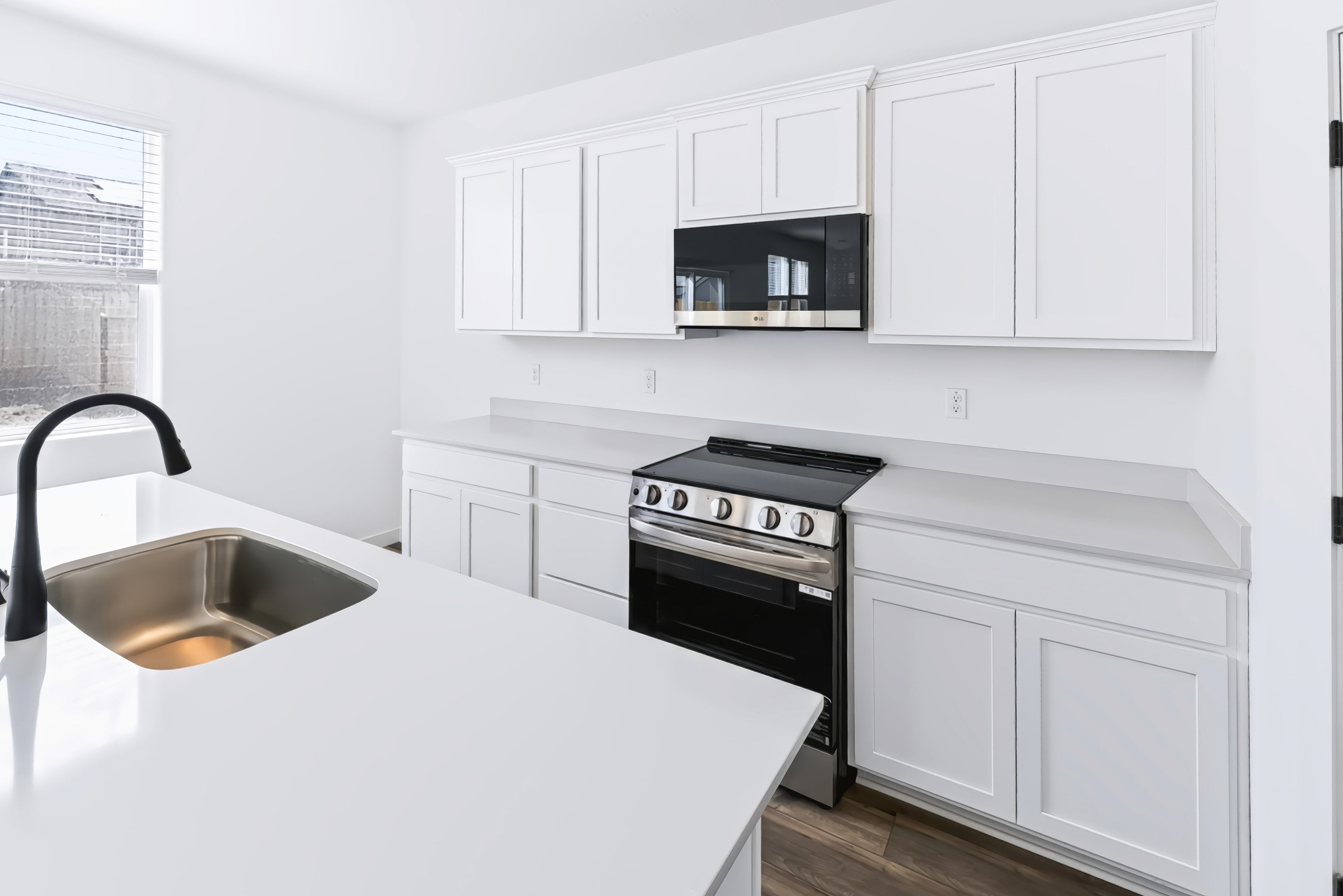 A kitchen with white cabinets.