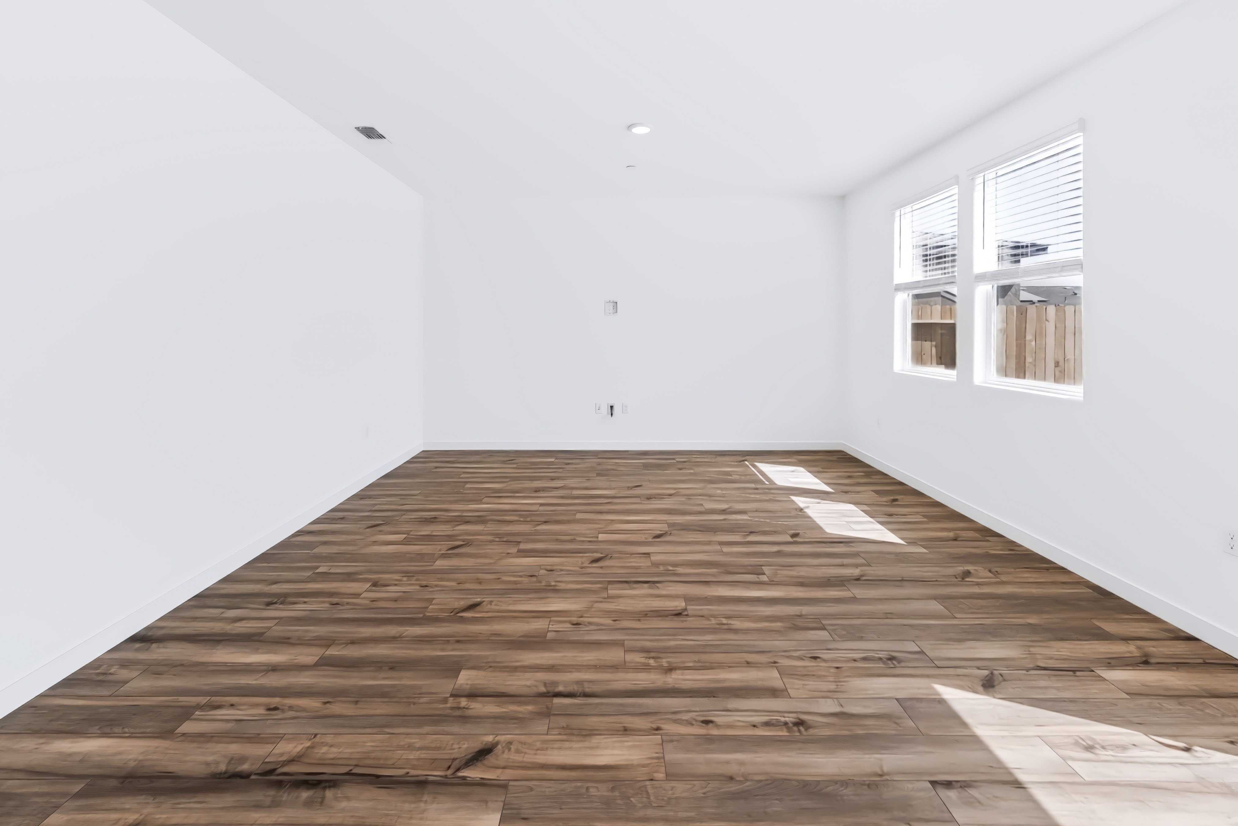A room with a wood floor and windows.