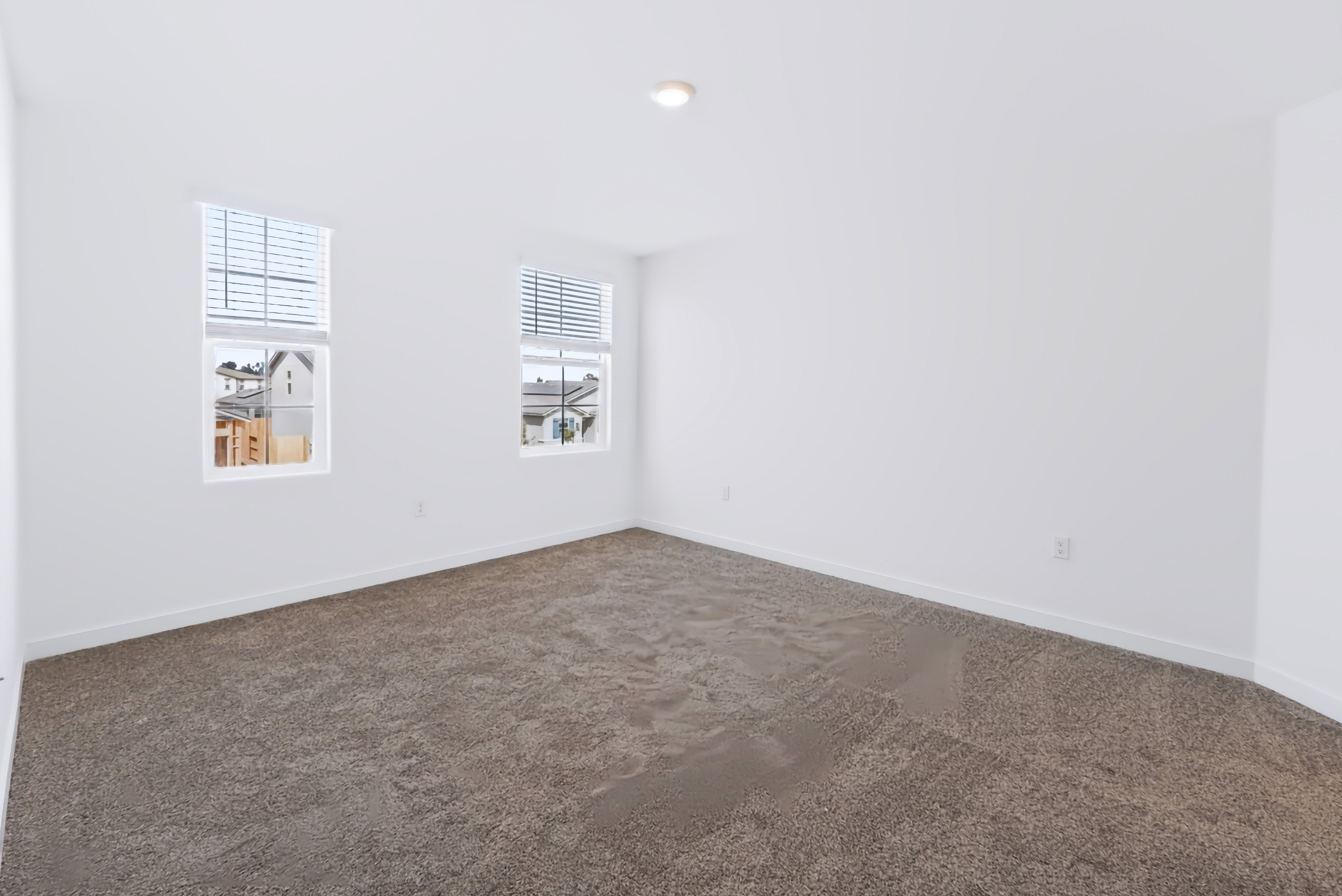 A room with a carpet and a window.