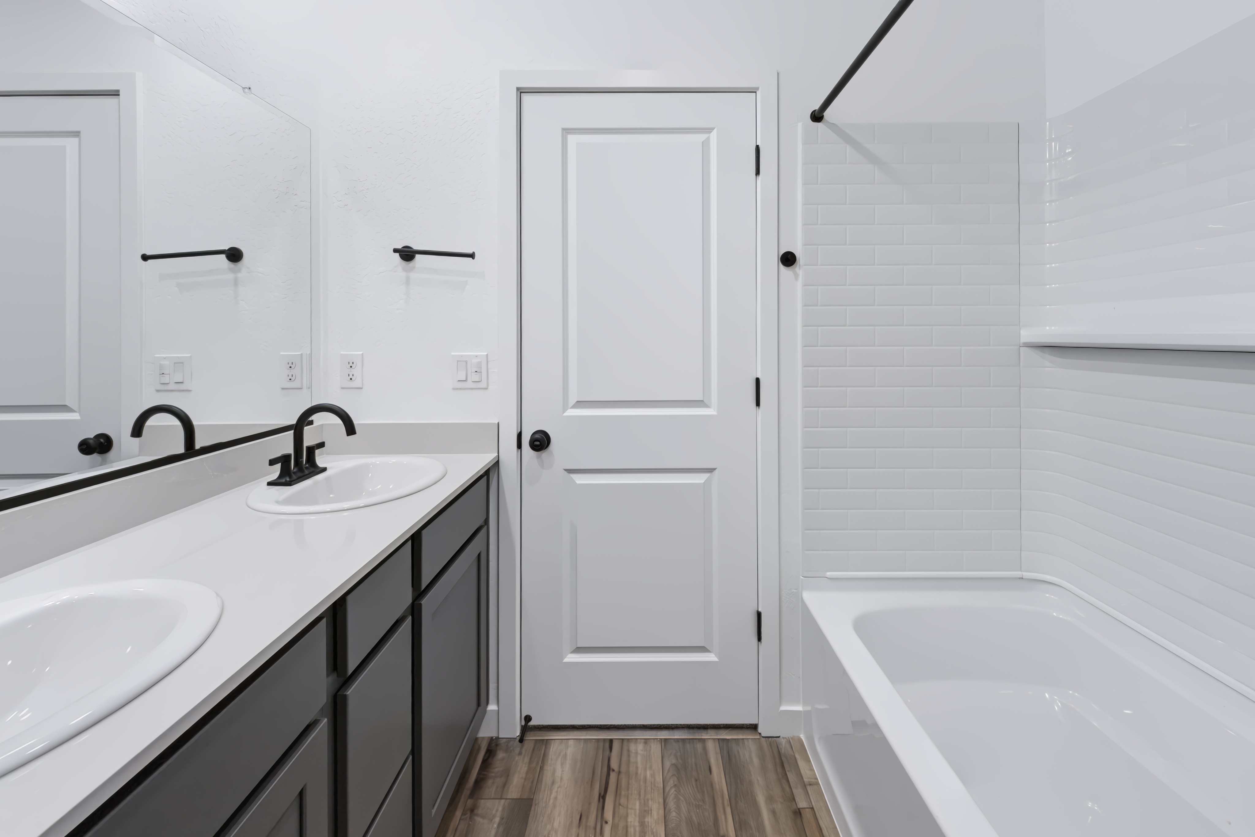A bathroom with a tub sink and a mirror.