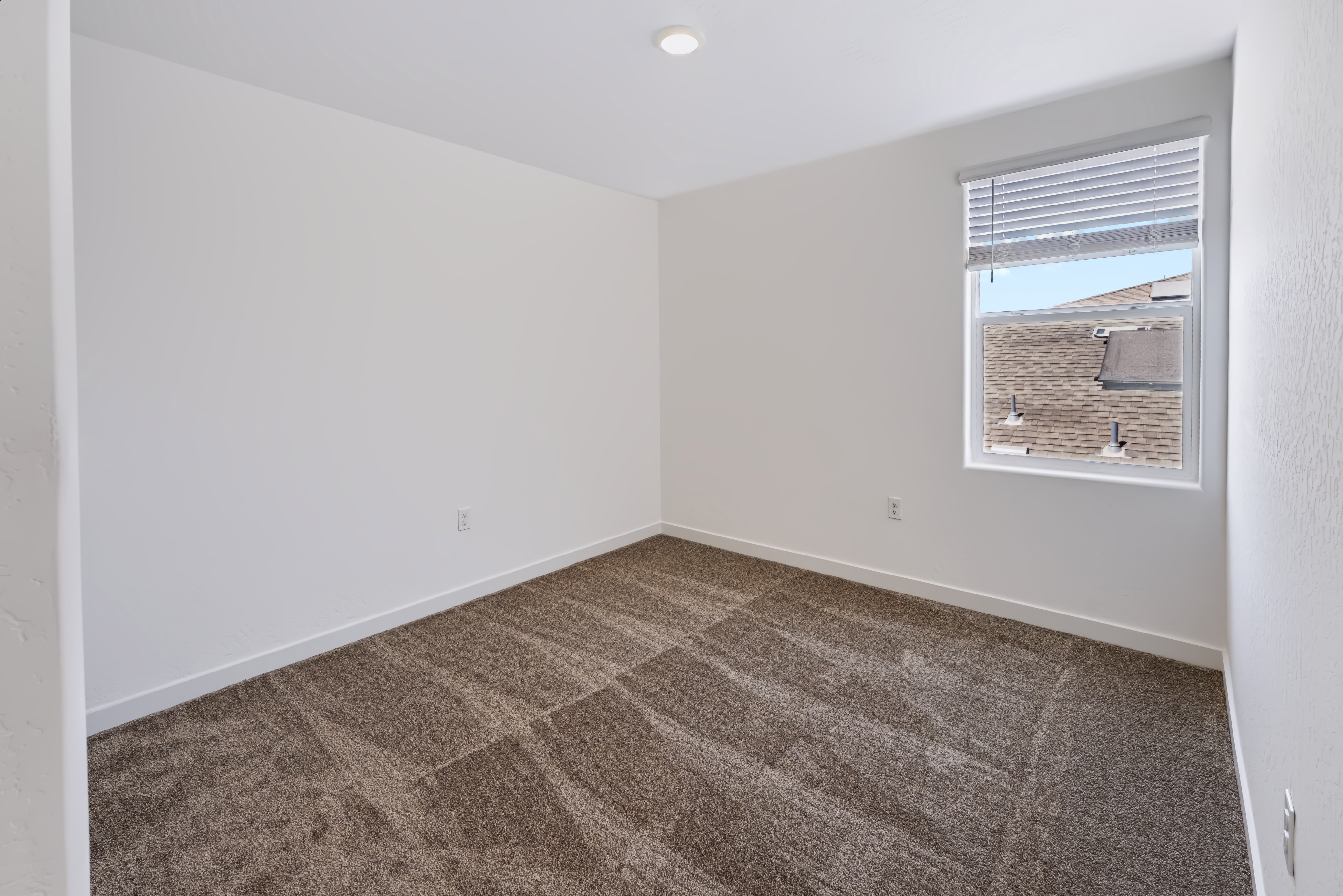 A room with a window and carpet.