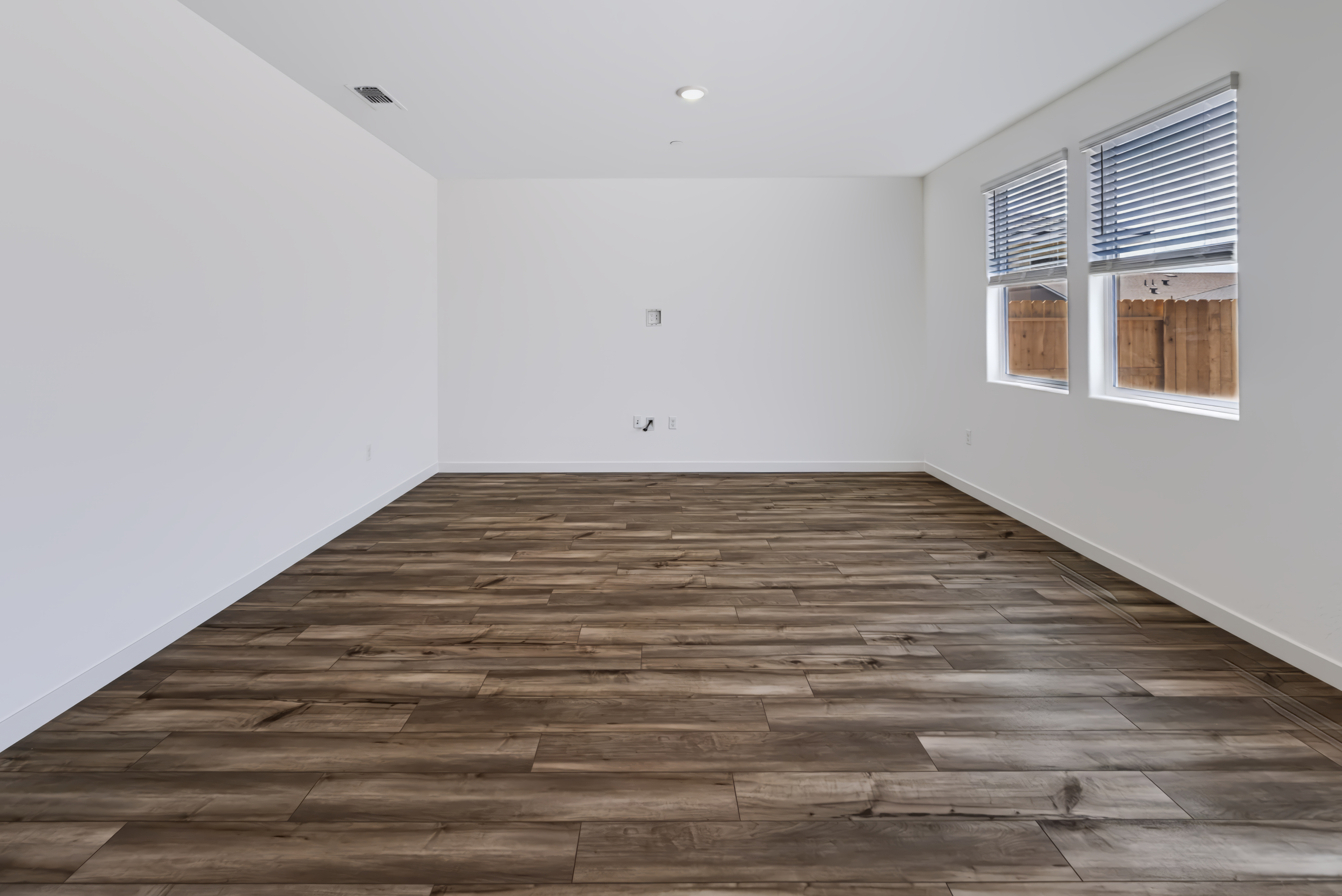 A room with a wood floor and windows.