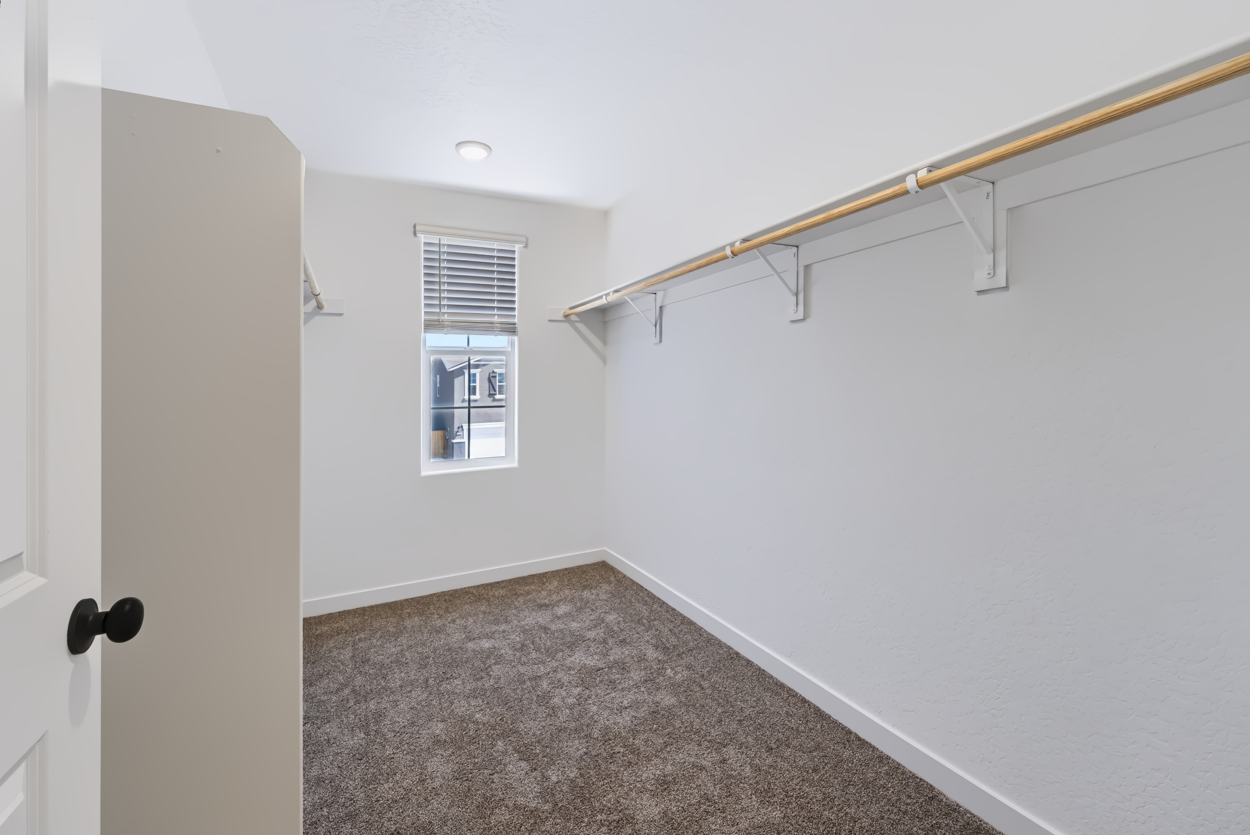 A hallway with a window and a carpet.