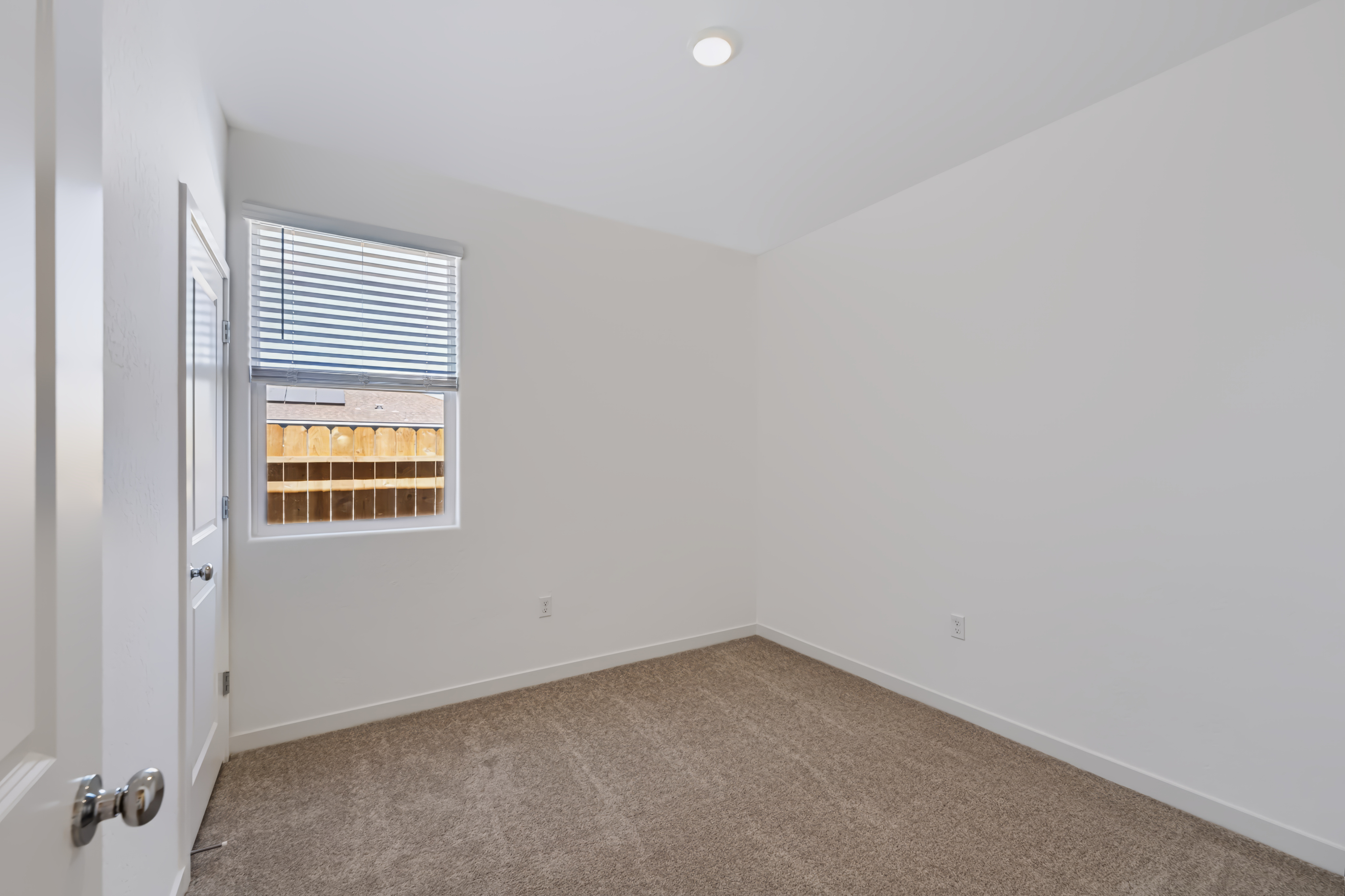 A room with a window and carpet.