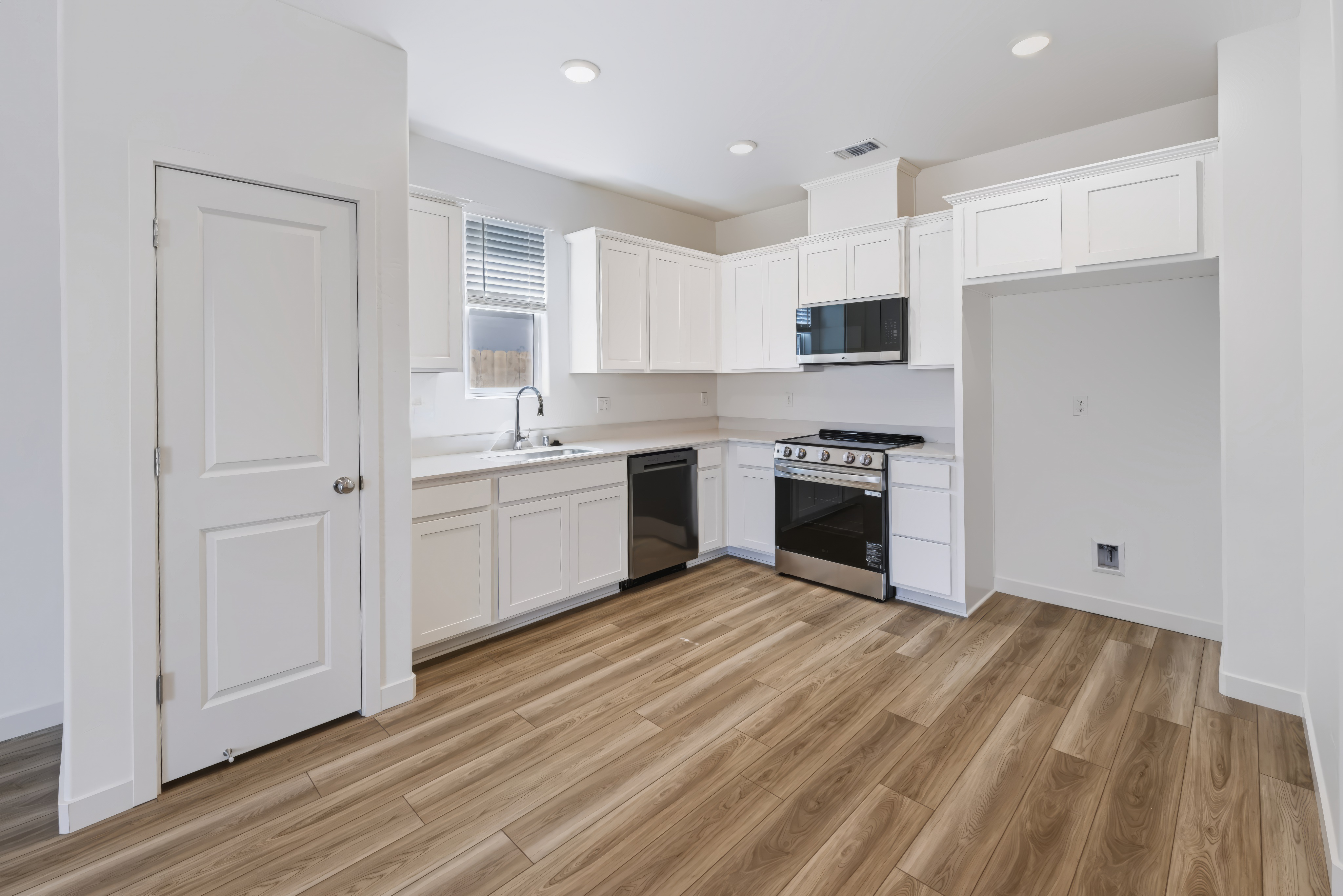 A kitchen with white cabinets.