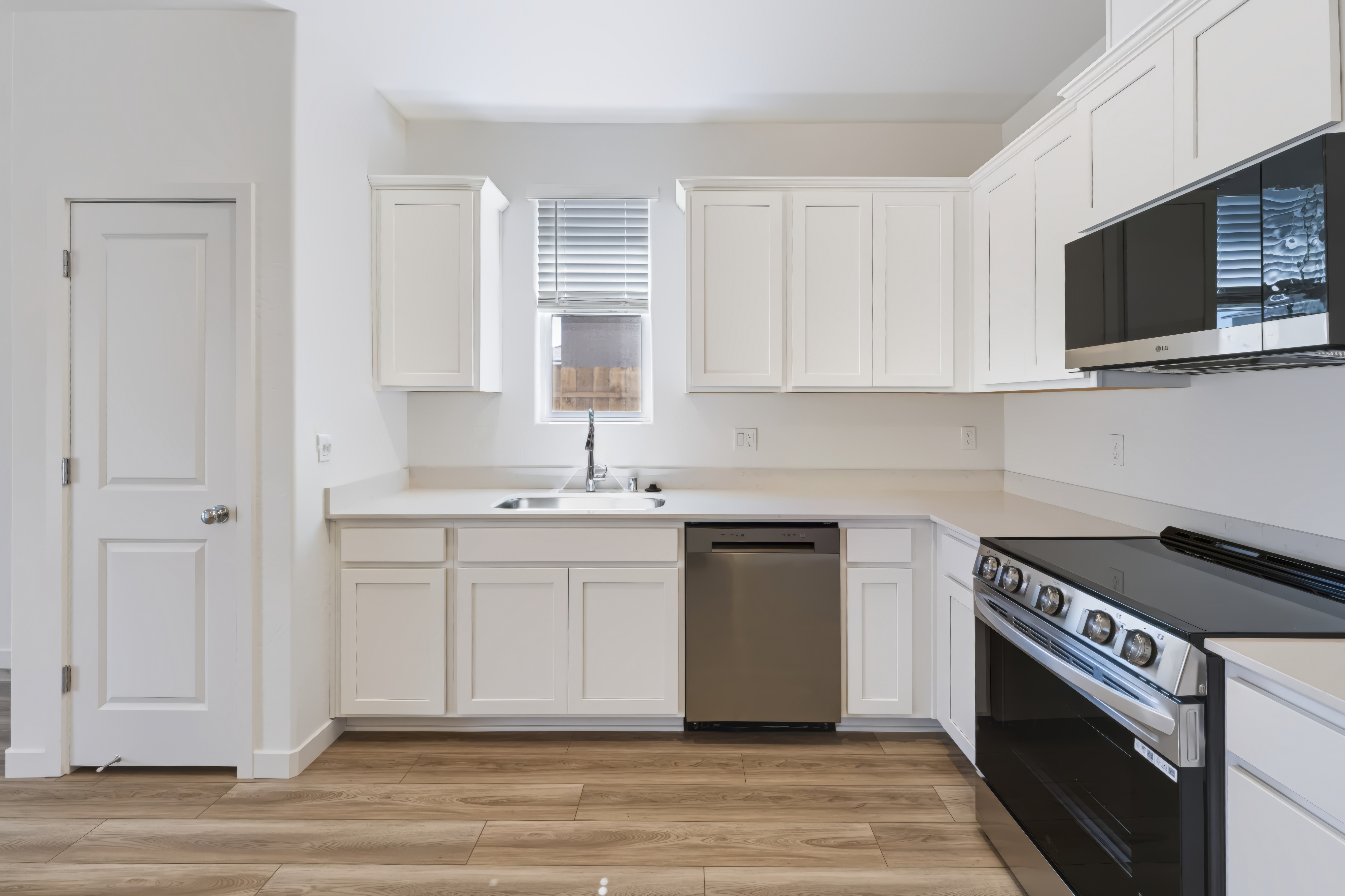 A kitchen with white cabinets.