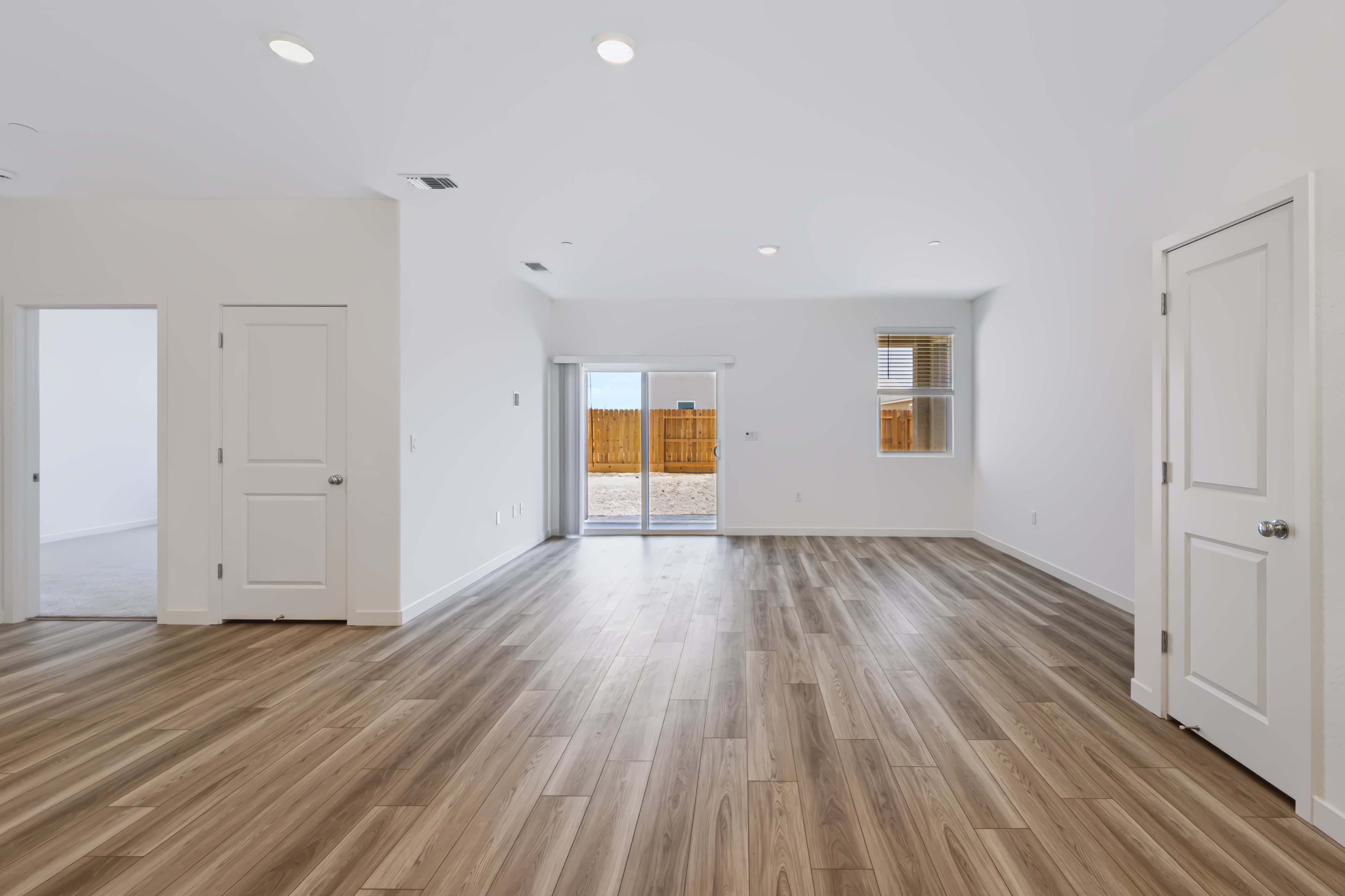 A room with white walls and wood floors.