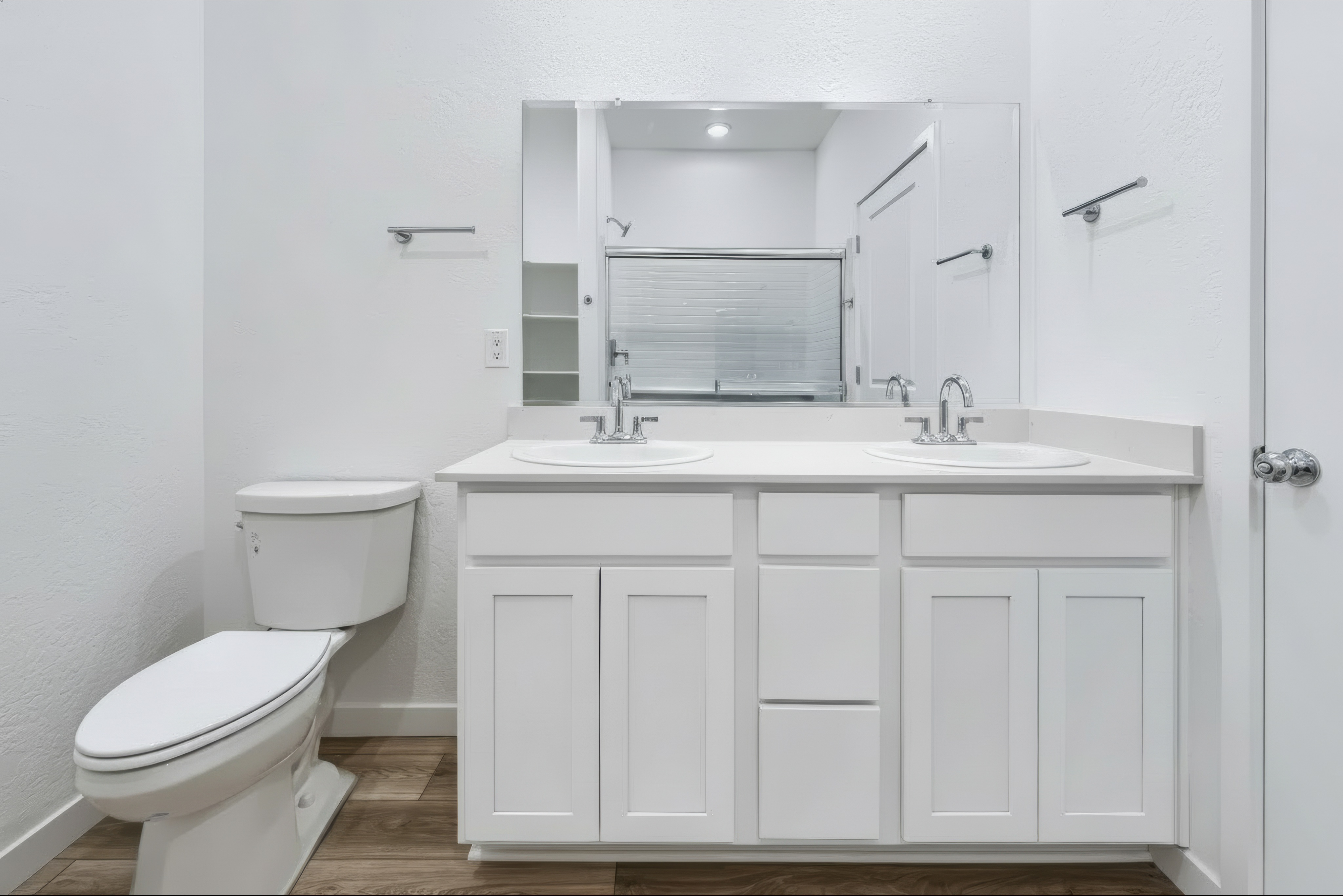 A bathroom with white cabinets.