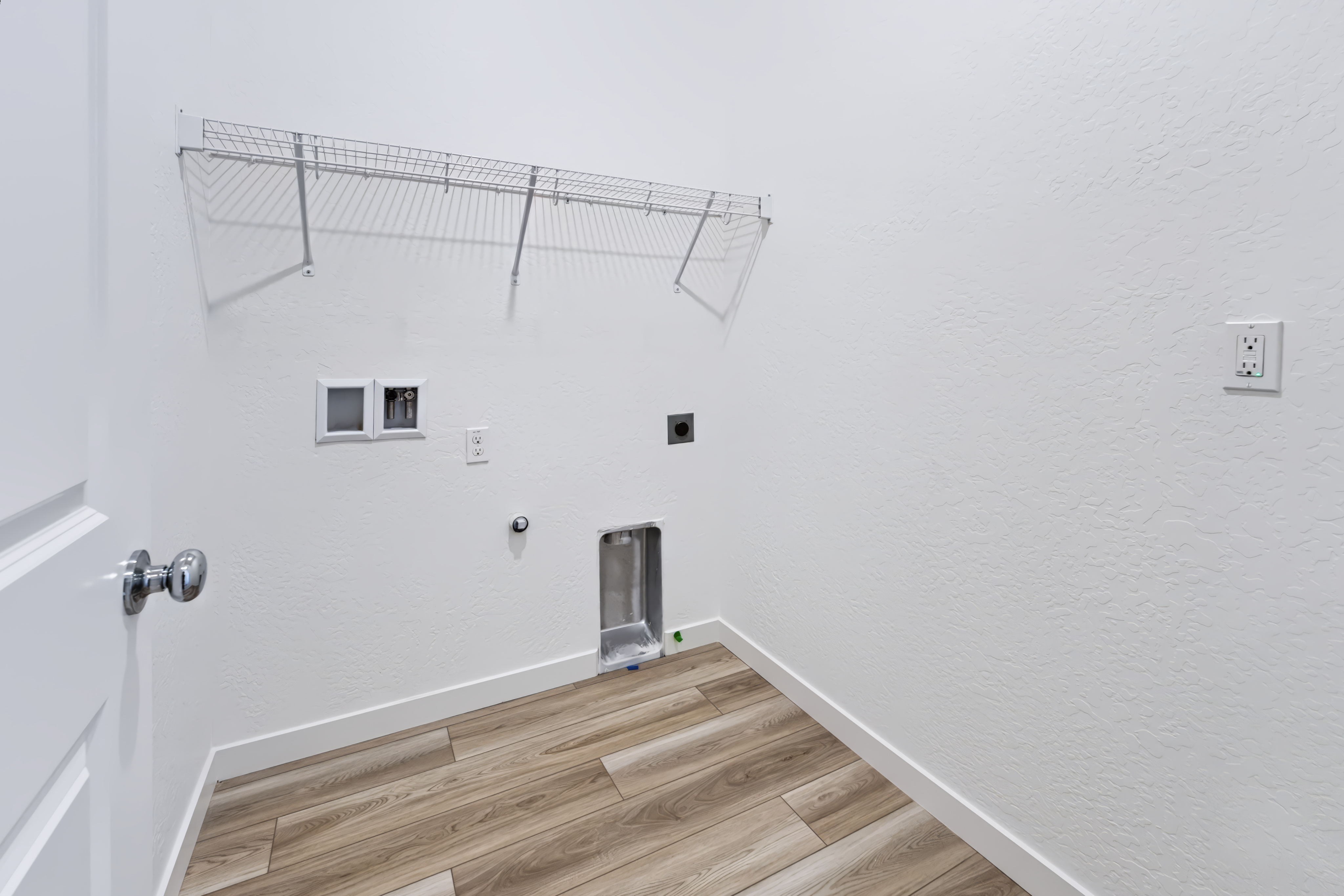 A room with a wood floor and a metal bar.