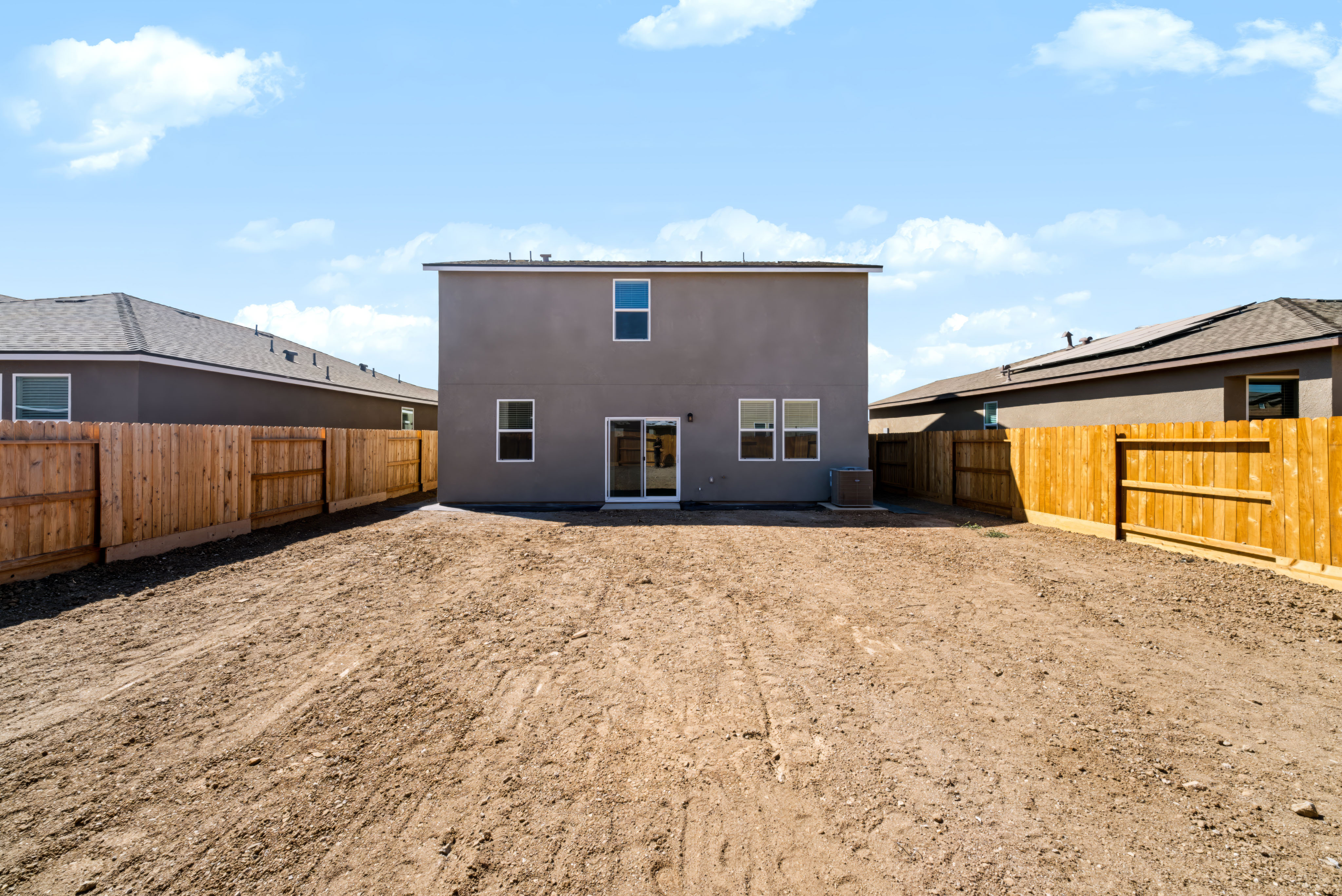 A dirt area with a building in the background.