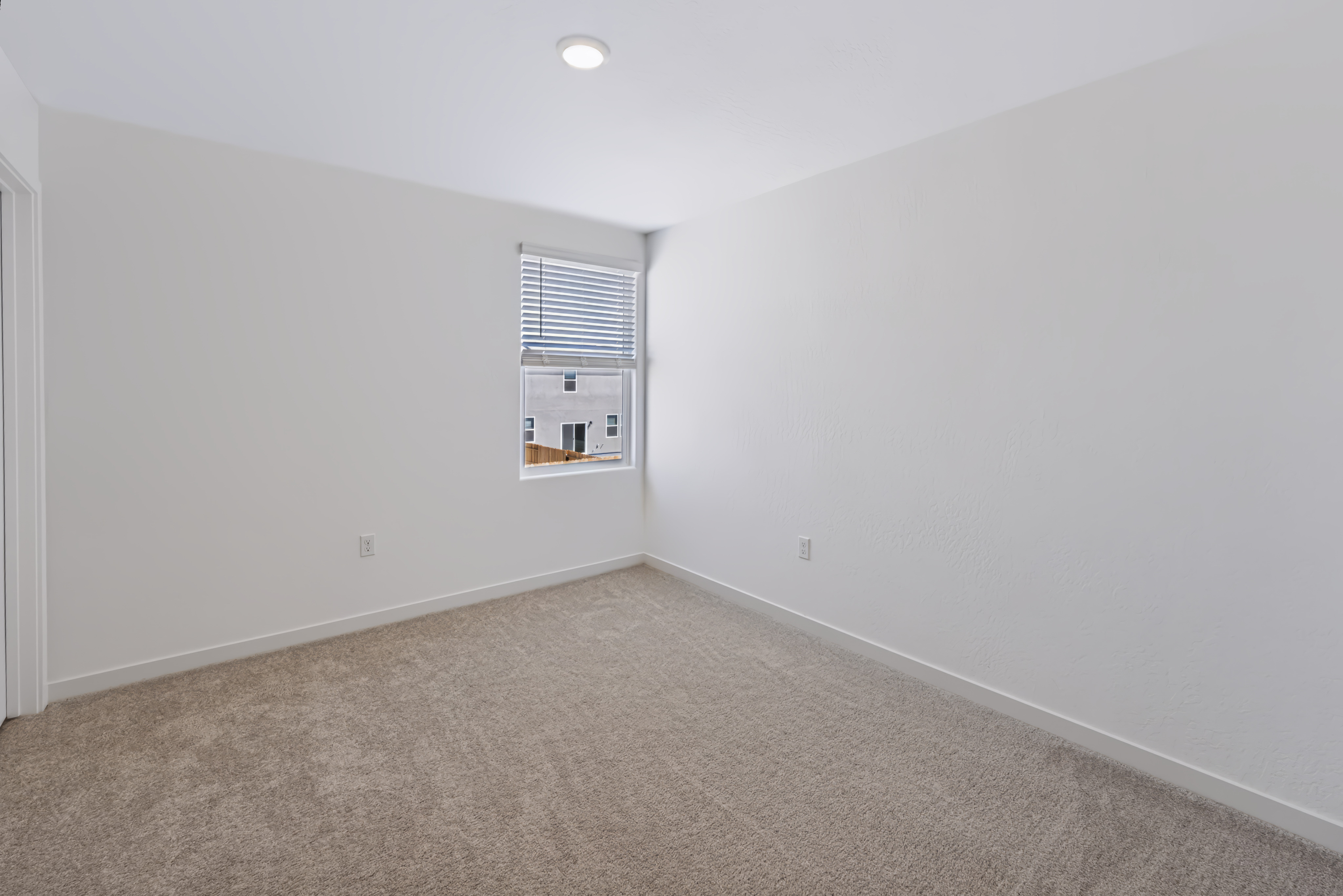 A room with a window and carpet.