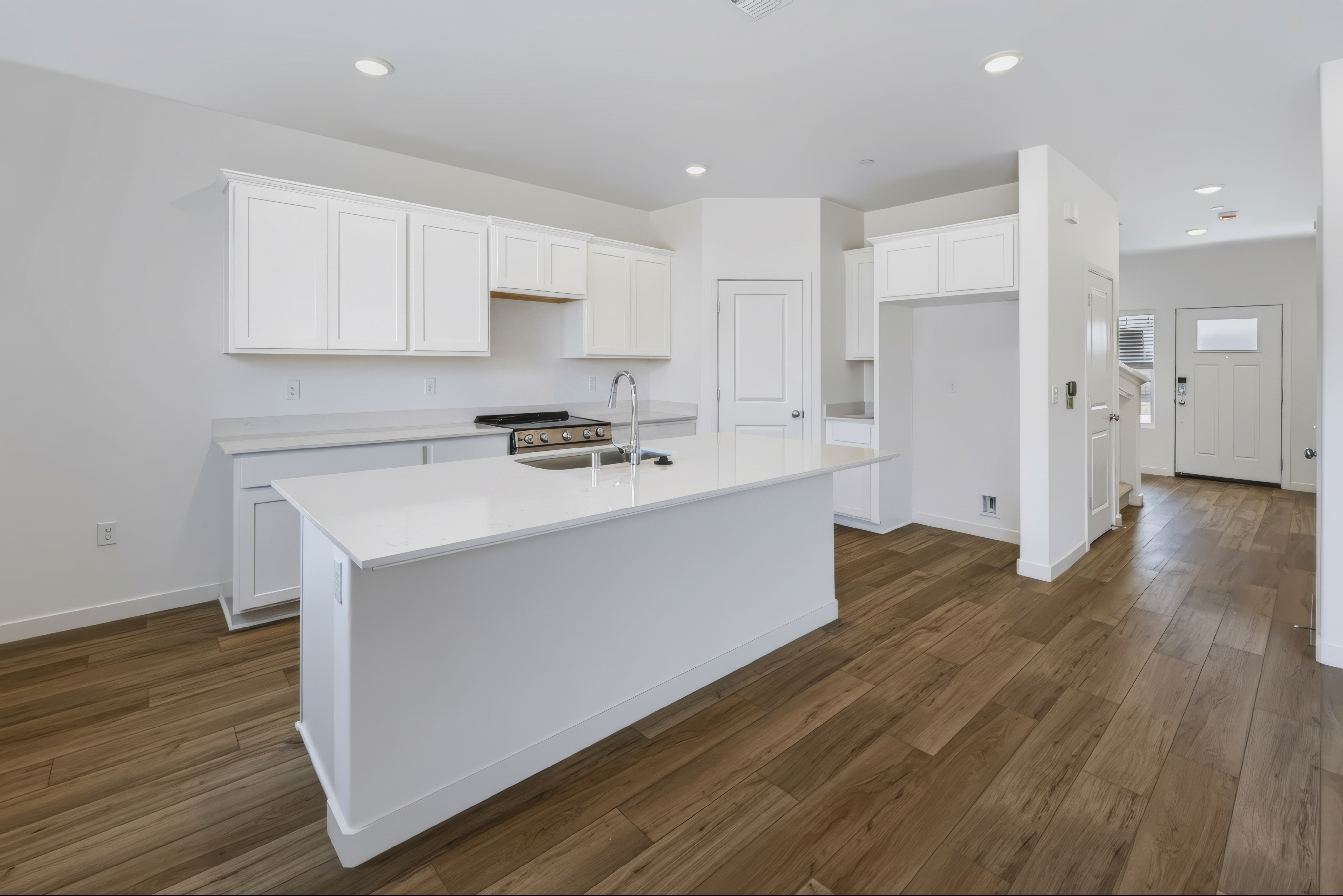 A kitchen with white cabinets.