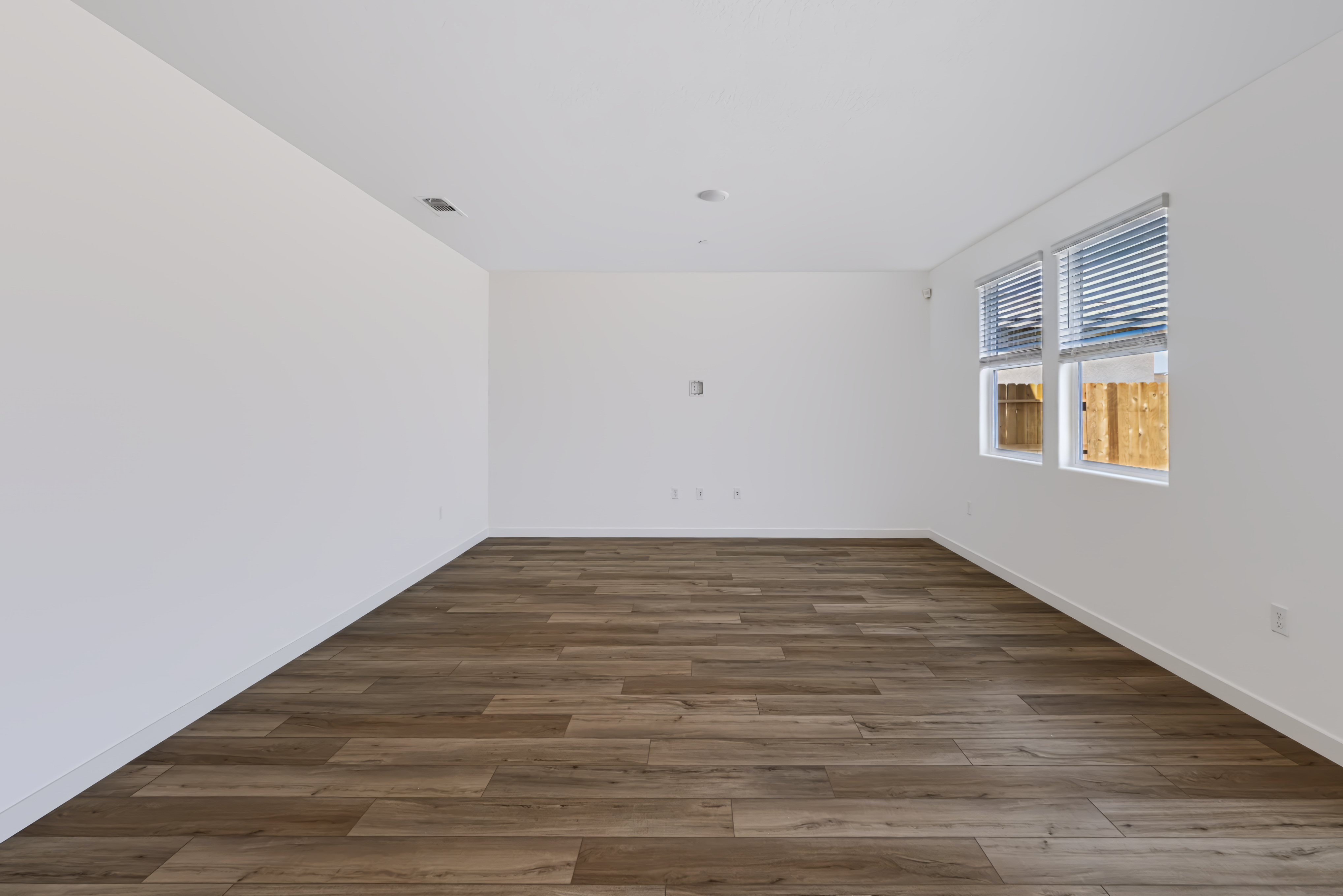 A room with a wood floor and windows.