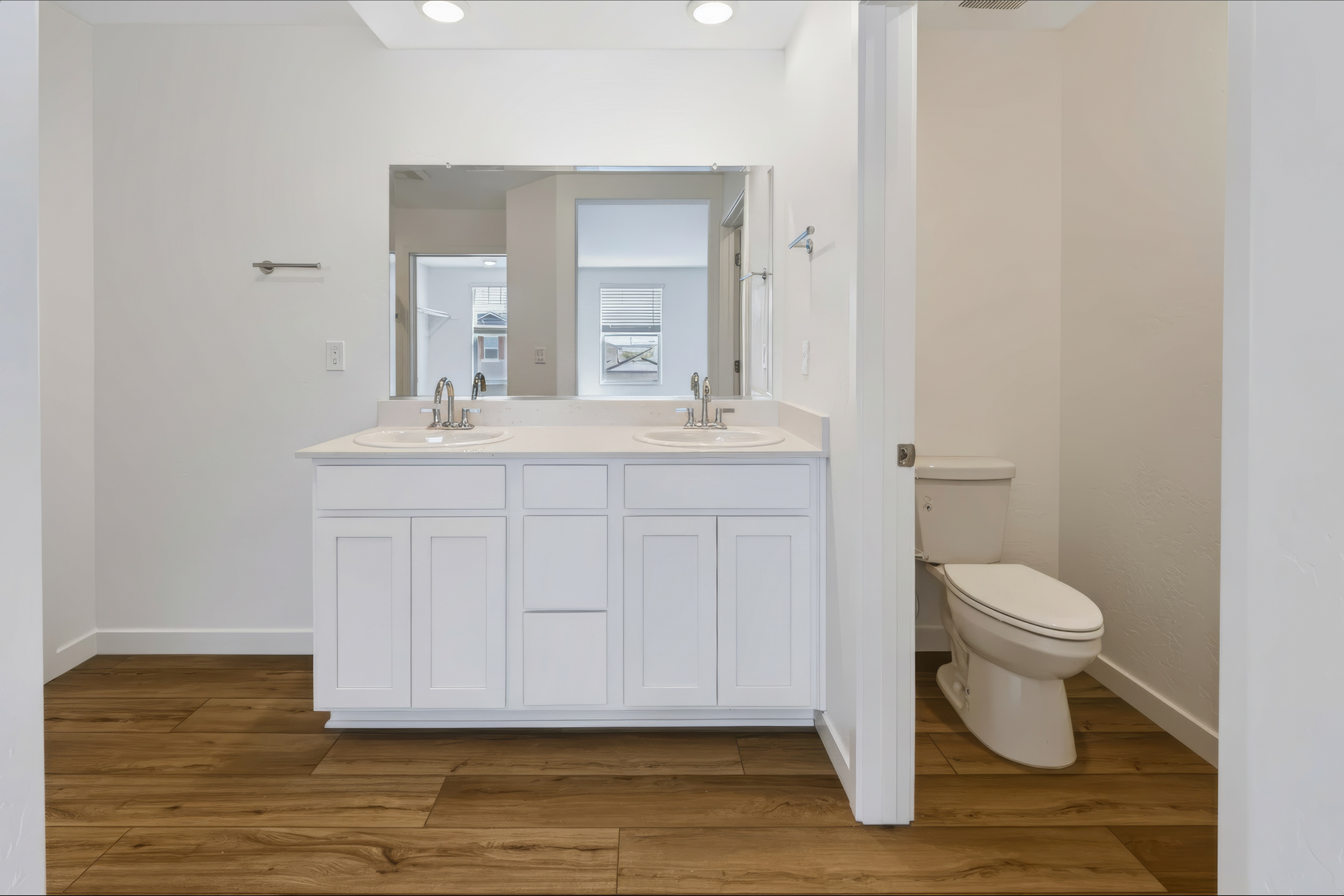 A bathroom with white cabinets.
