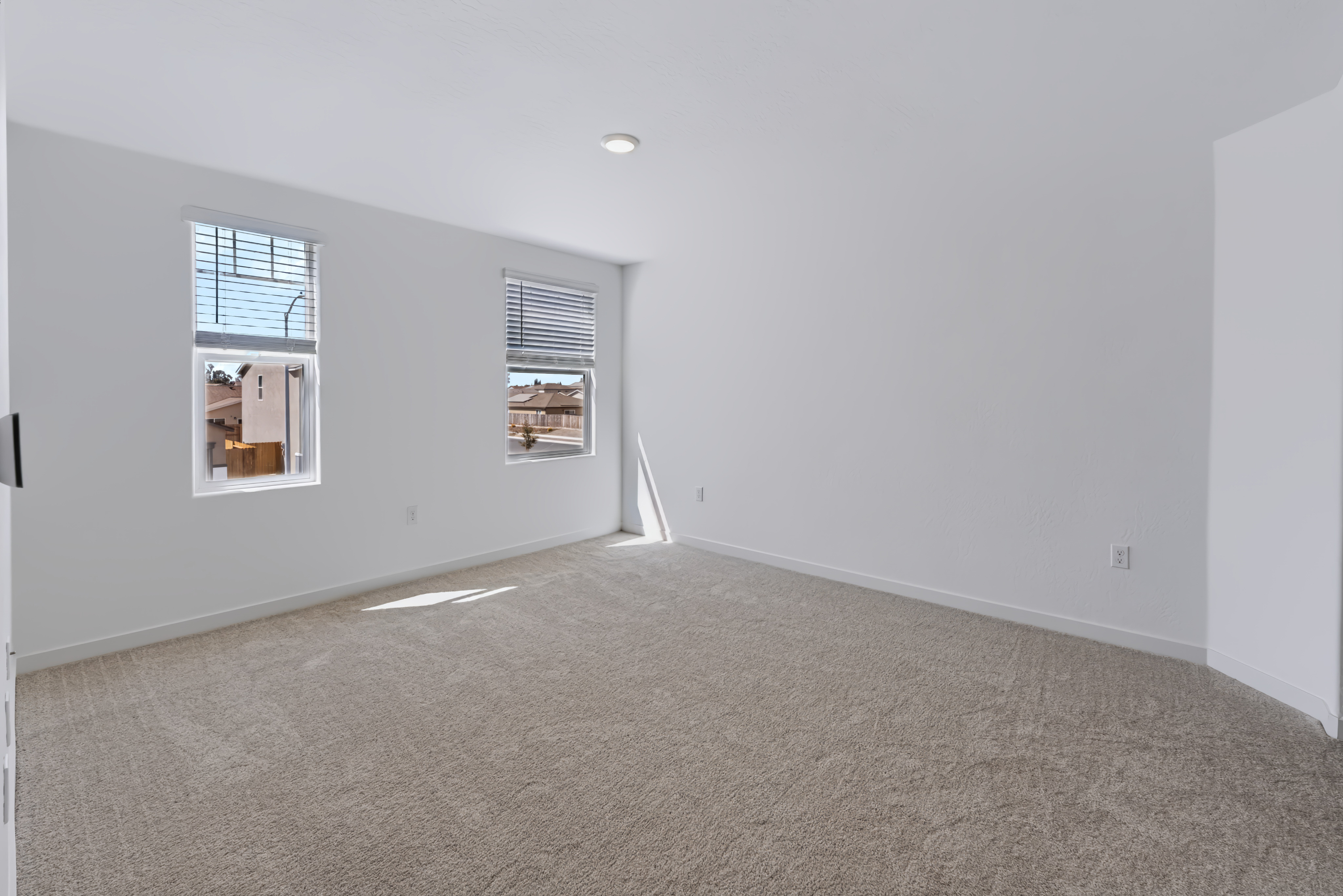A room with a carpet and windows.
