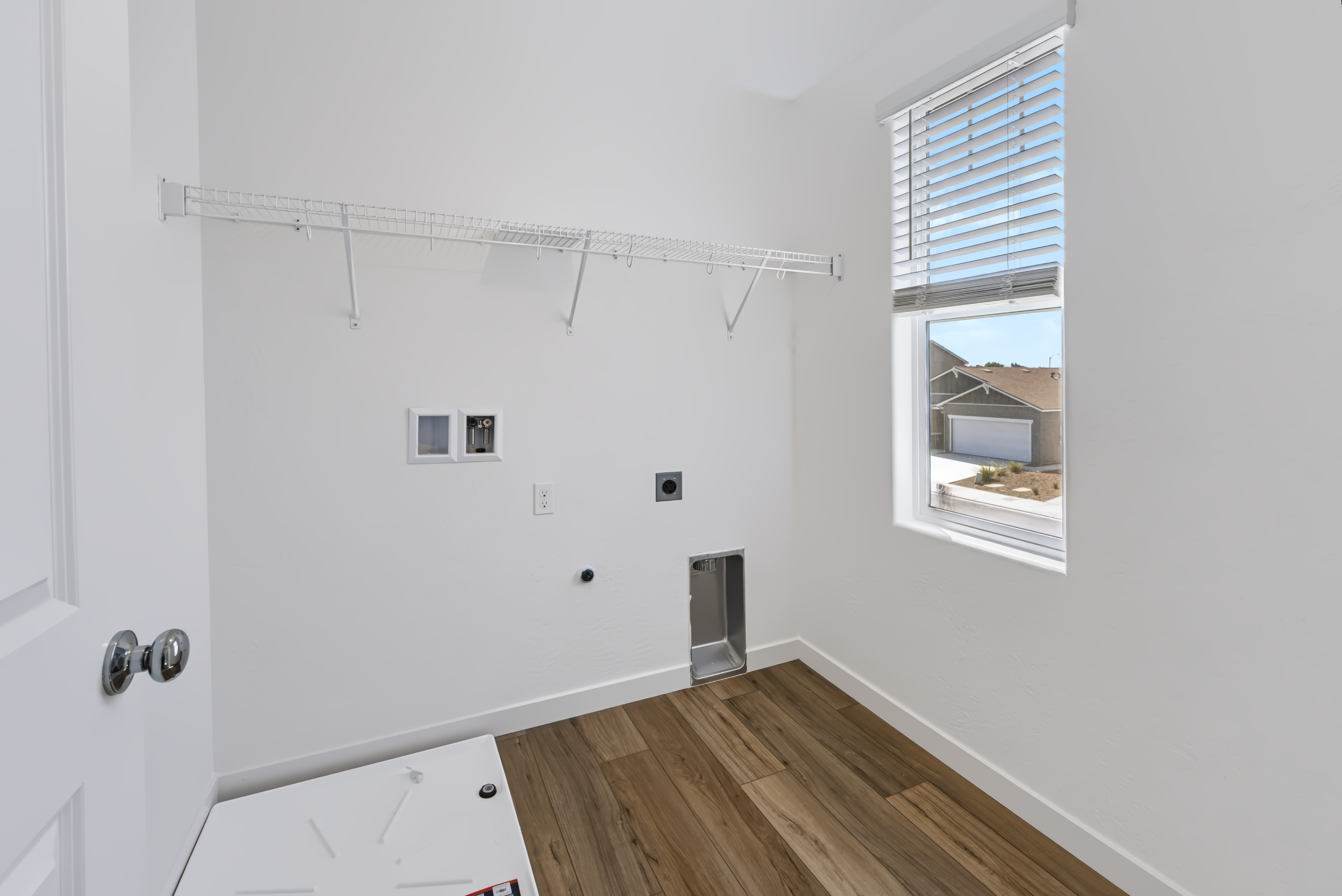 A room with a wood floor and a window with a wood floor.