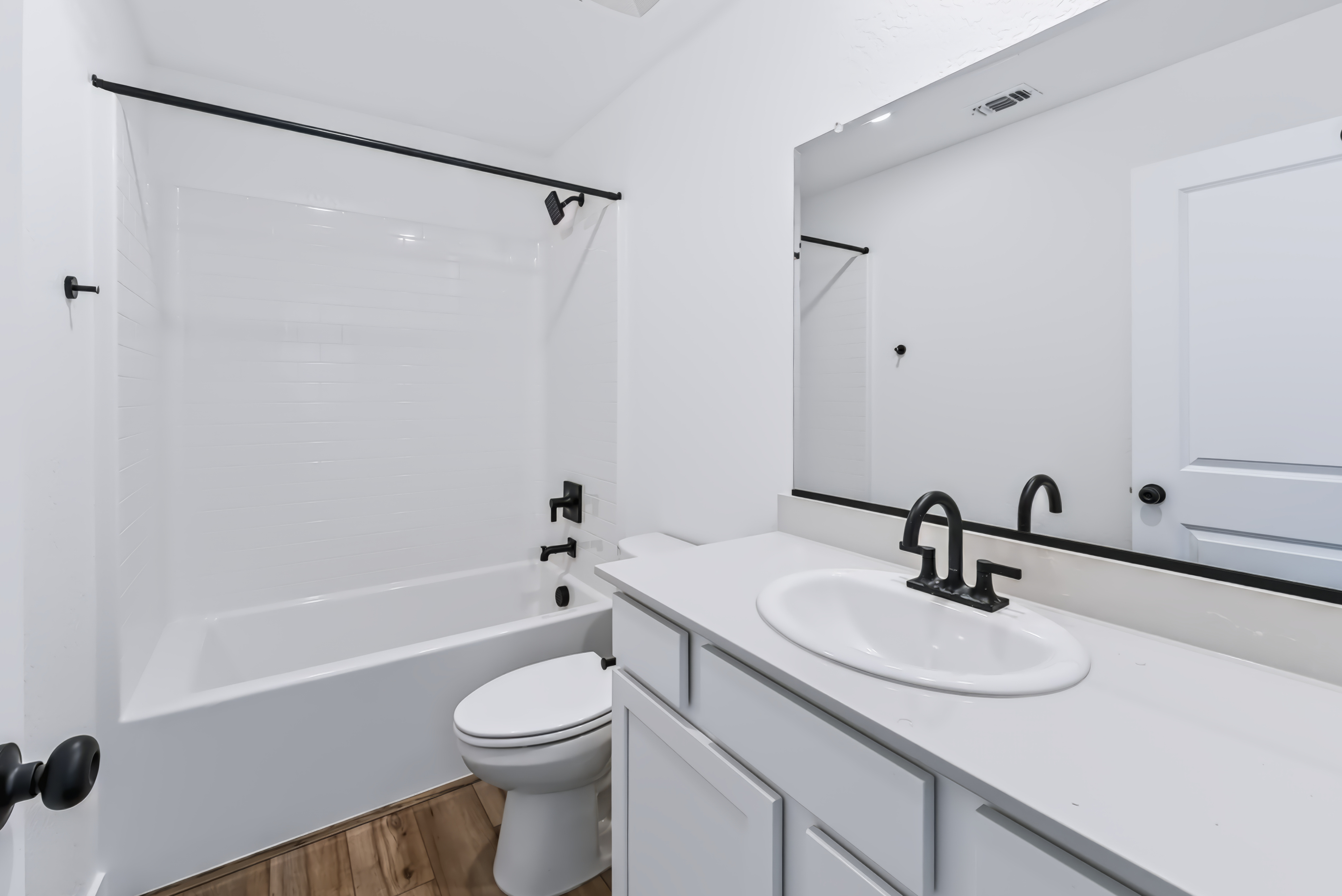 A bathroom with a sink toilet and bathtub.