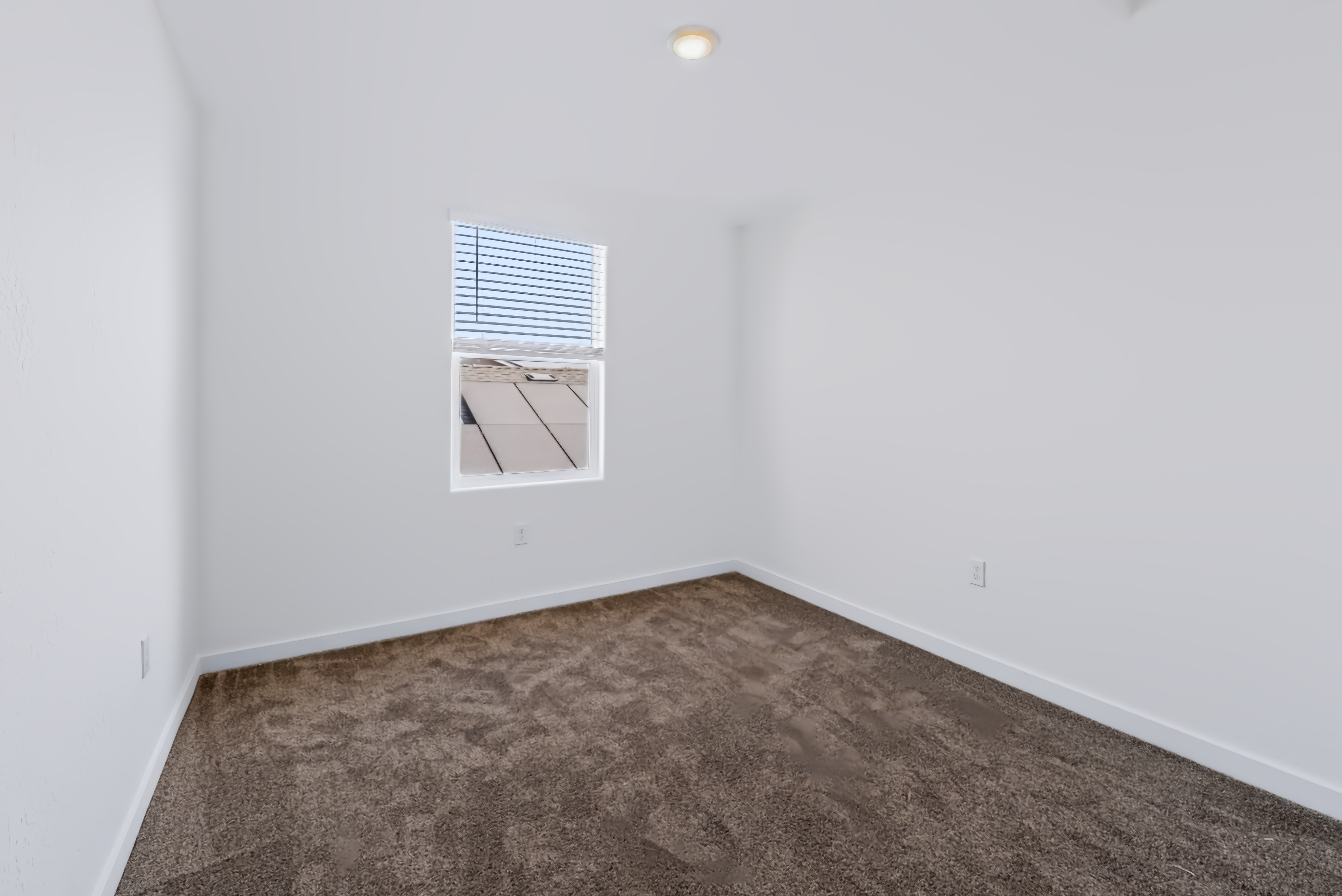 A room with a window and carpet.