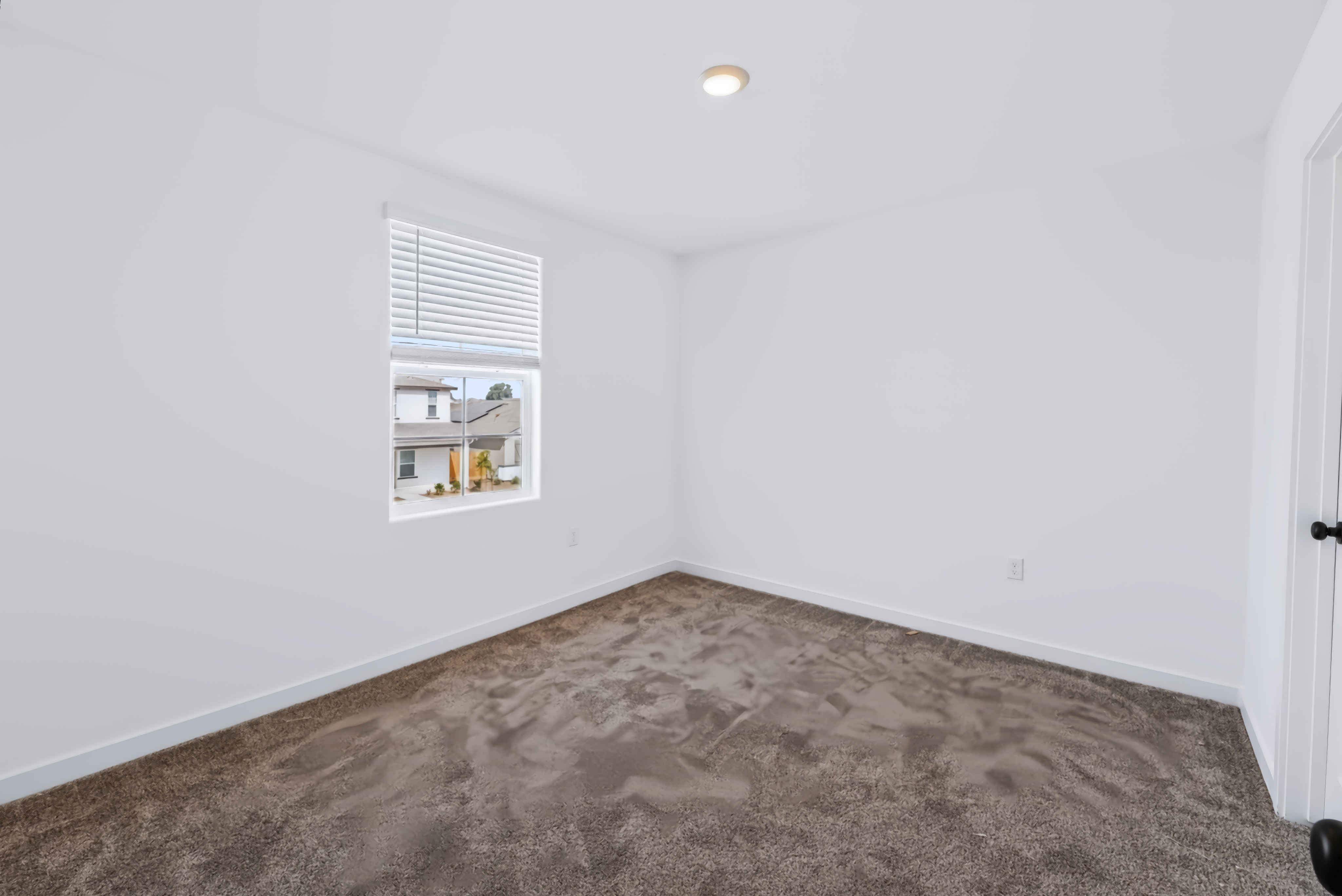 A room with a carpet and a window.
