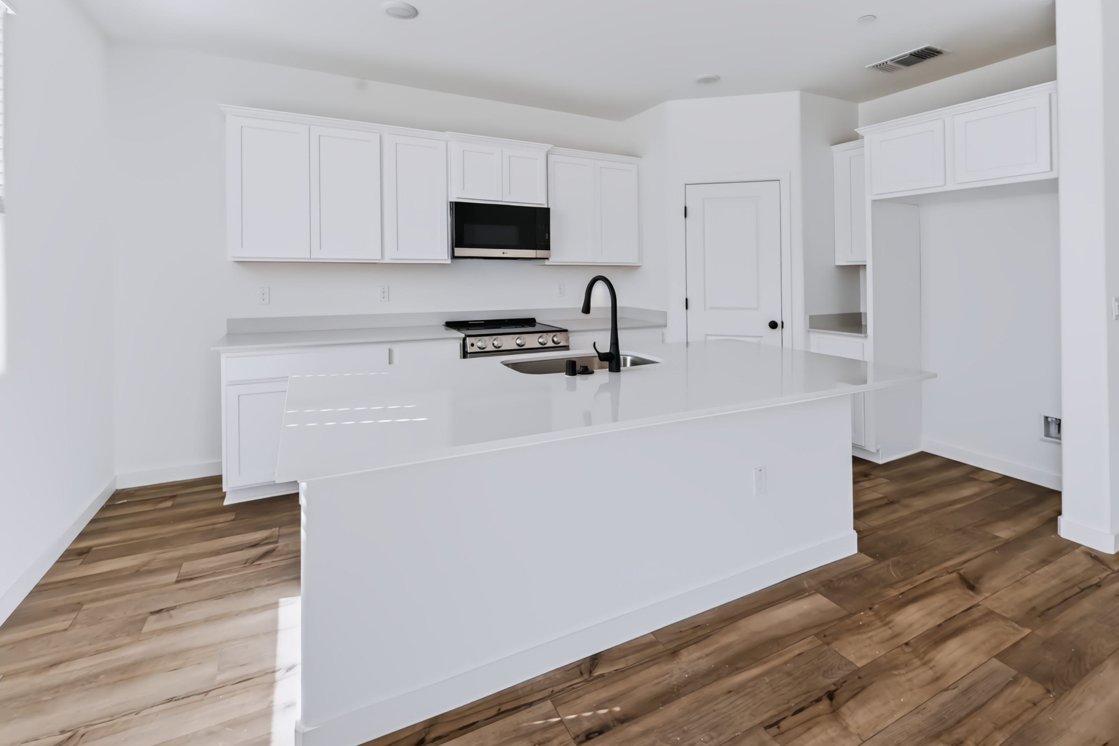 A kitchen with white cabinets.