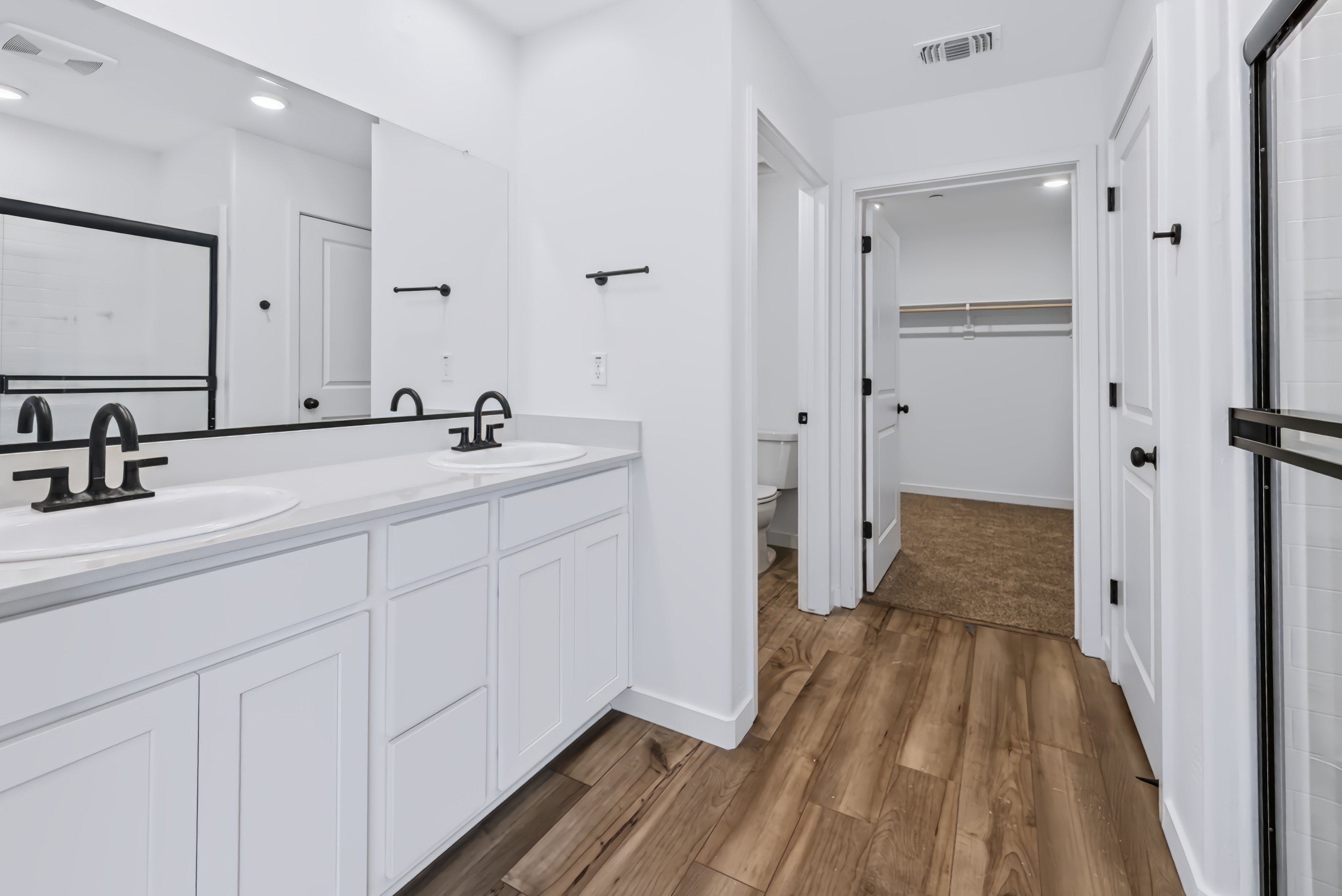 A bathroom with white cabinets.