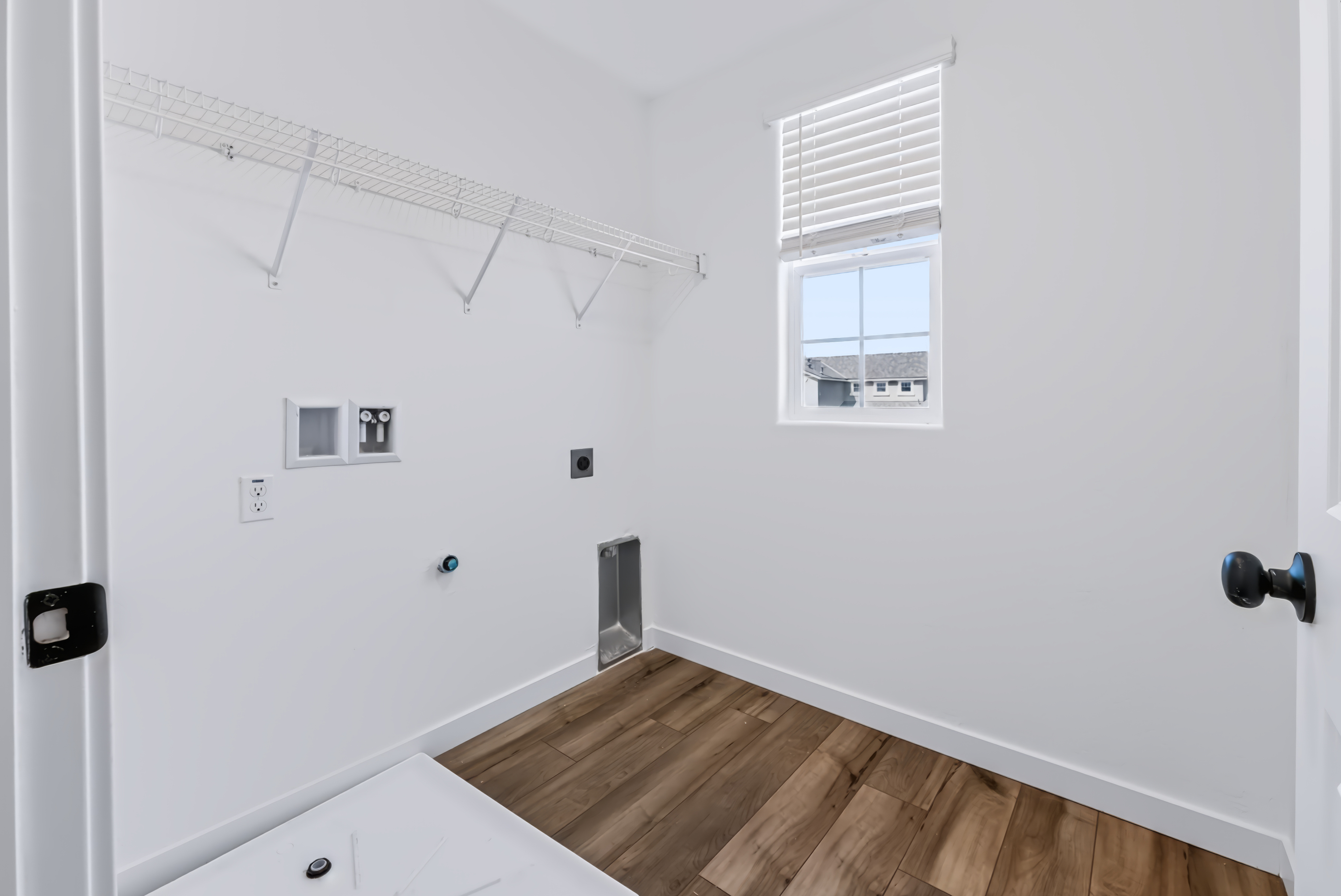 A room with a wood floor and a wood floor with a window.