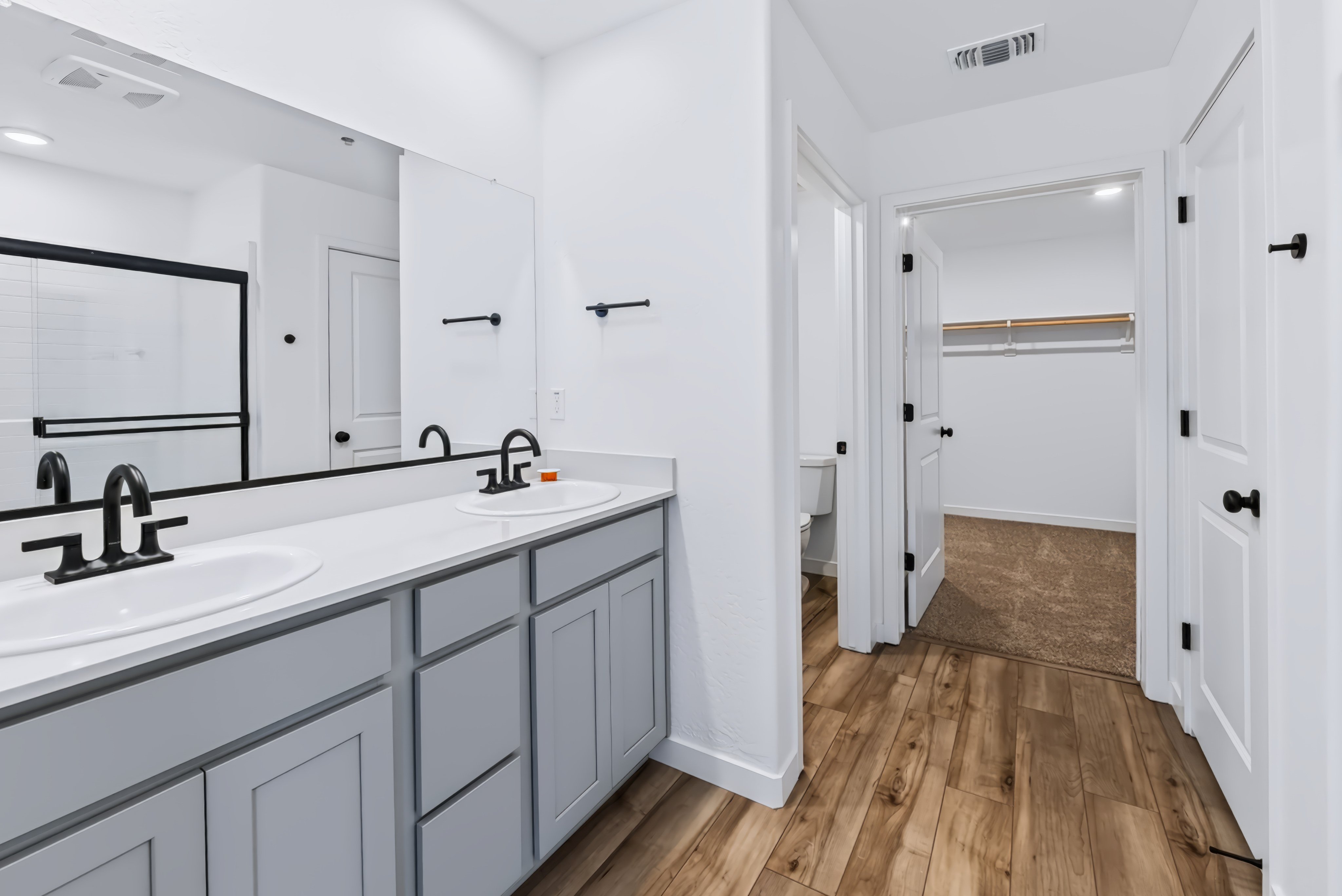 A bathroom with white cabinets.
