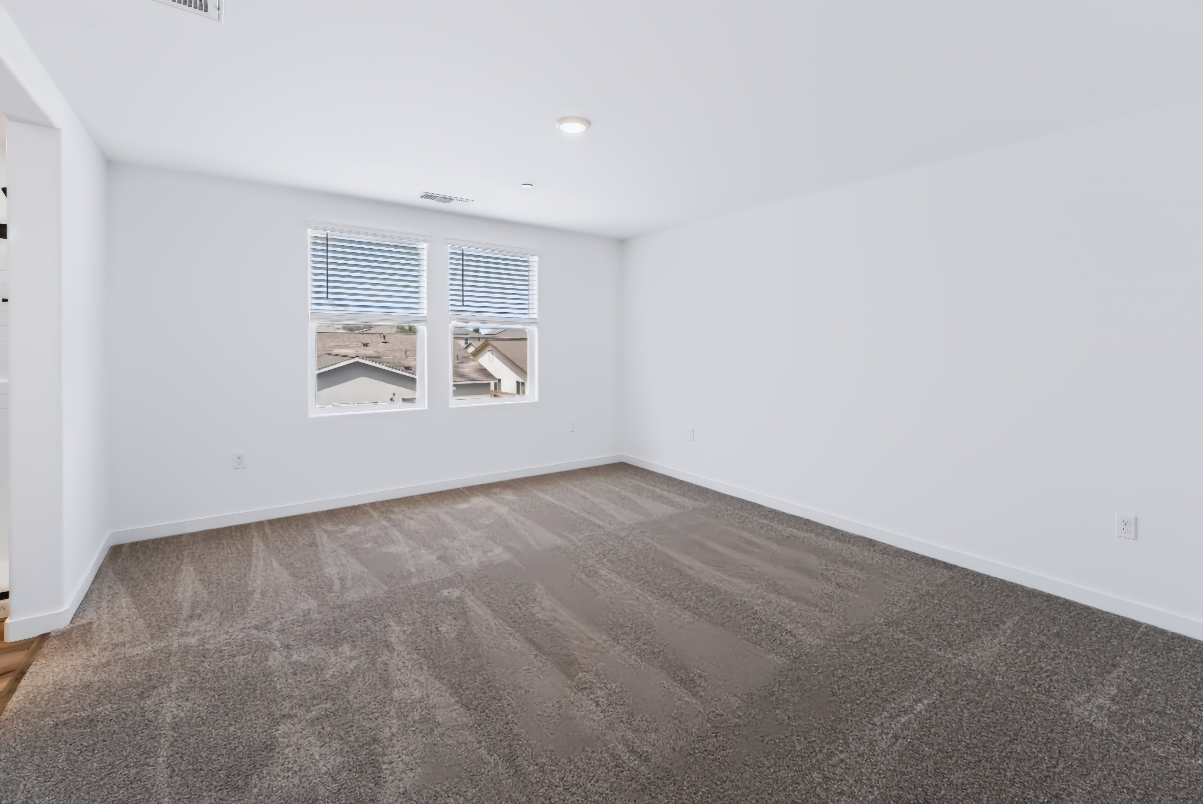 A room with a carpet and a window.