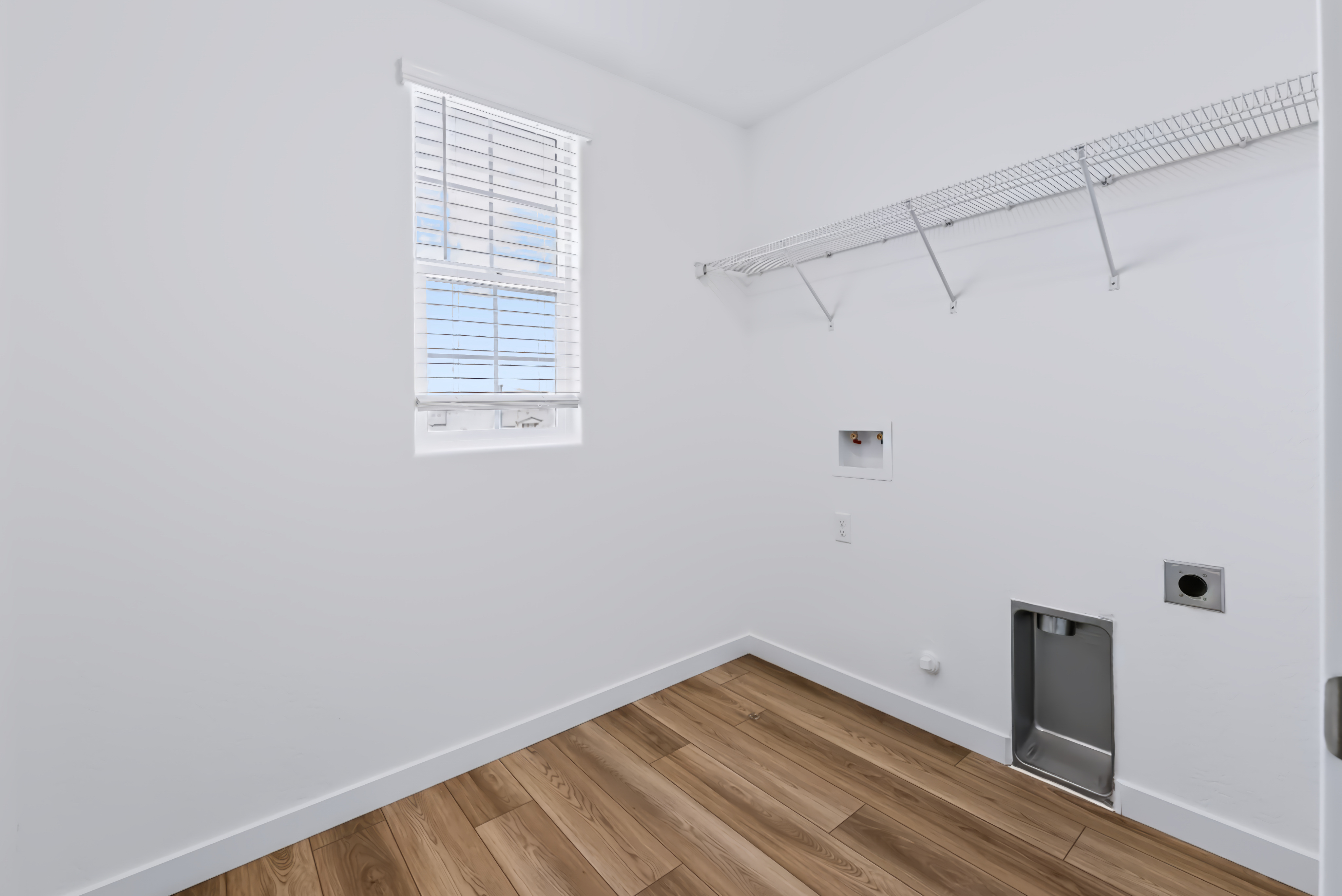 A room with a wood floor and a wood floor with a window.