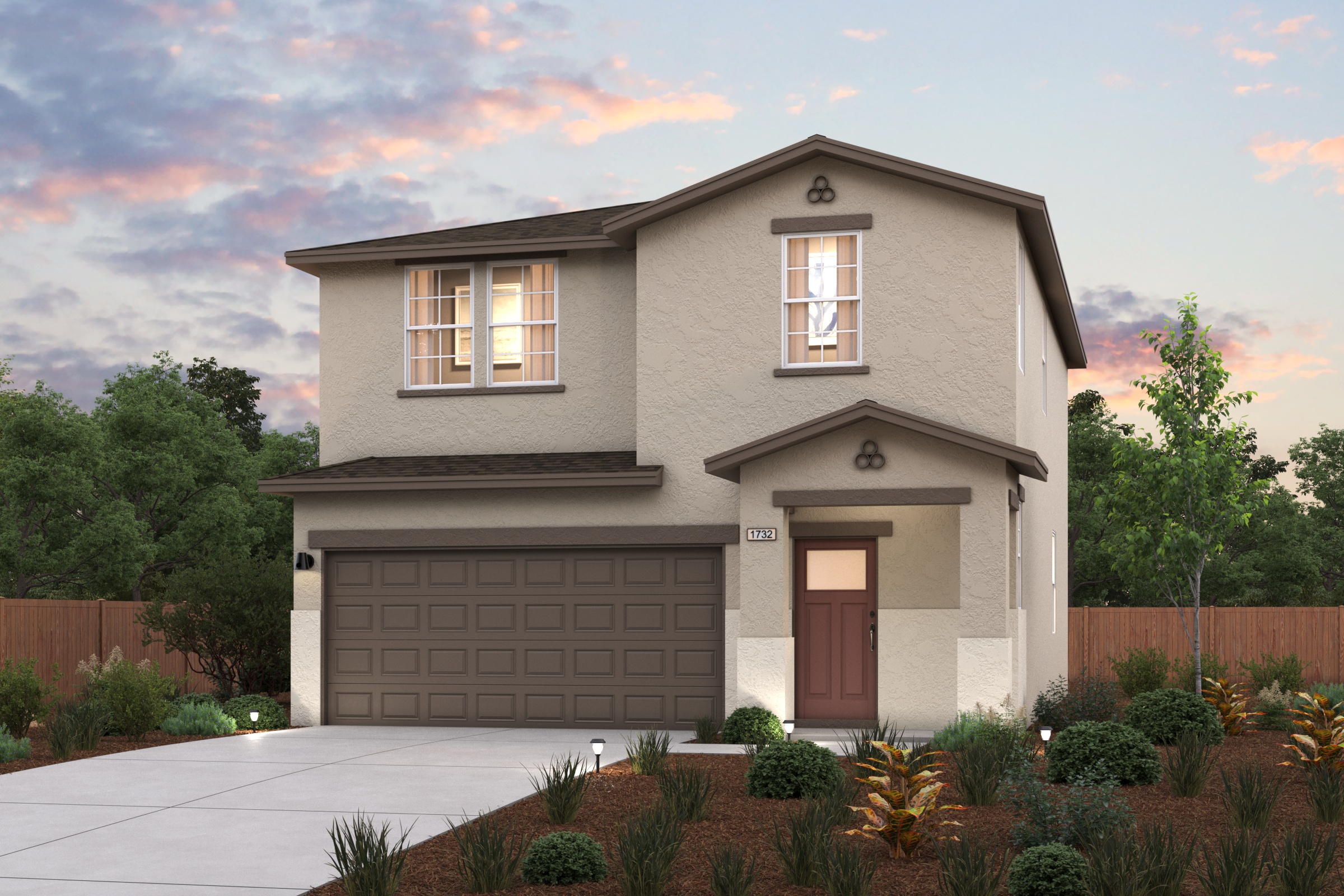 A house with a garage and bushes in front of it.