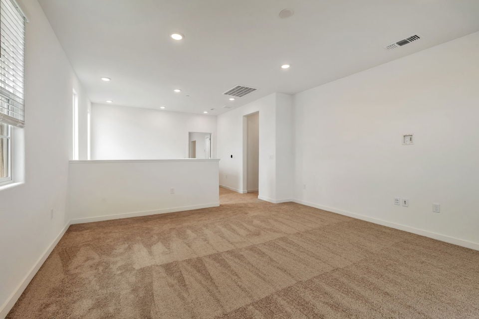 A room with a carpet and a window.