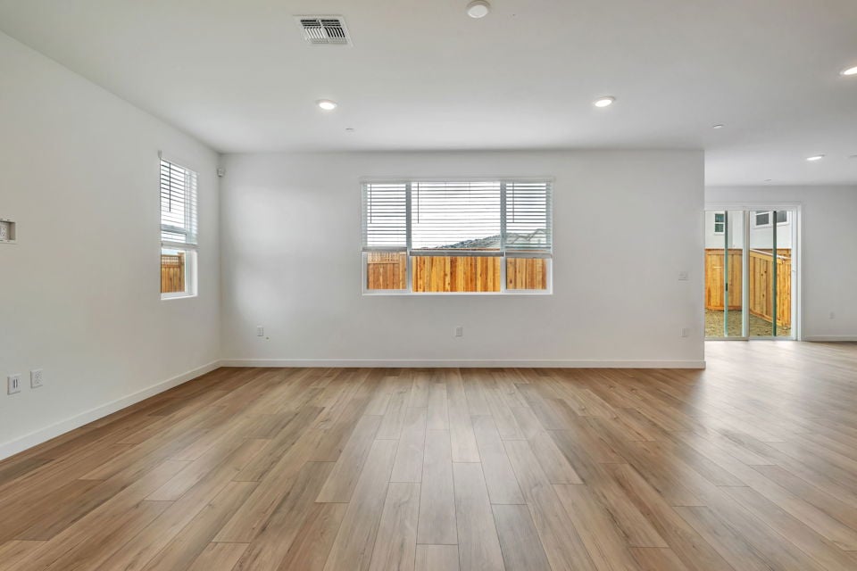 A room with a wood floor and a wood floor with a window.